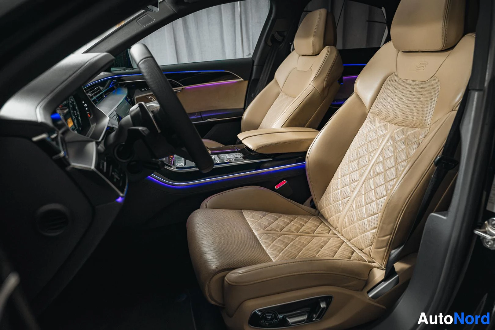 Etuistuimet: Musta Audi A8, beige tikattu nahkainen etuistuin avoimesta ovesta kuvattuna