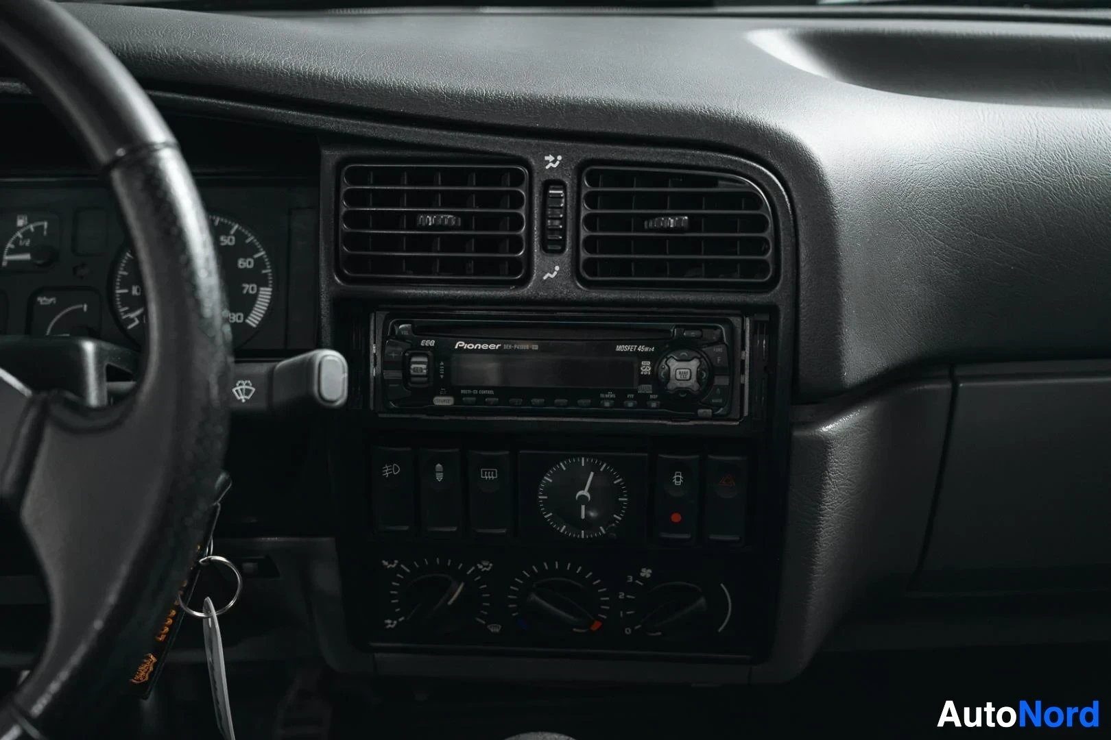 Yksityiskohta: Tummansininen Renault 19, keskikonsoli, ilmastoinnin suuttimet ja radio