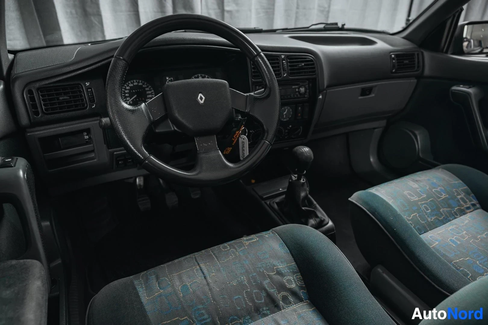 Ohjaamo: Tummansininen Renault 19, kojelauta ja etuistuimet matkustajan puolelta, kuvioitu kangasverhoilu