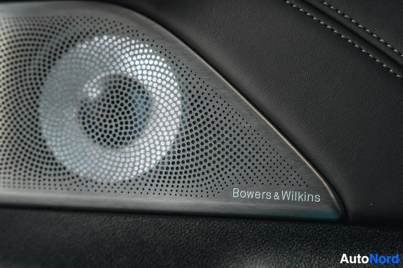 Yksityiskohta: Hopeanharmaa BMW 540i G31 xDrive Touring, Bowers & Wilkins -kaiutin ovessa