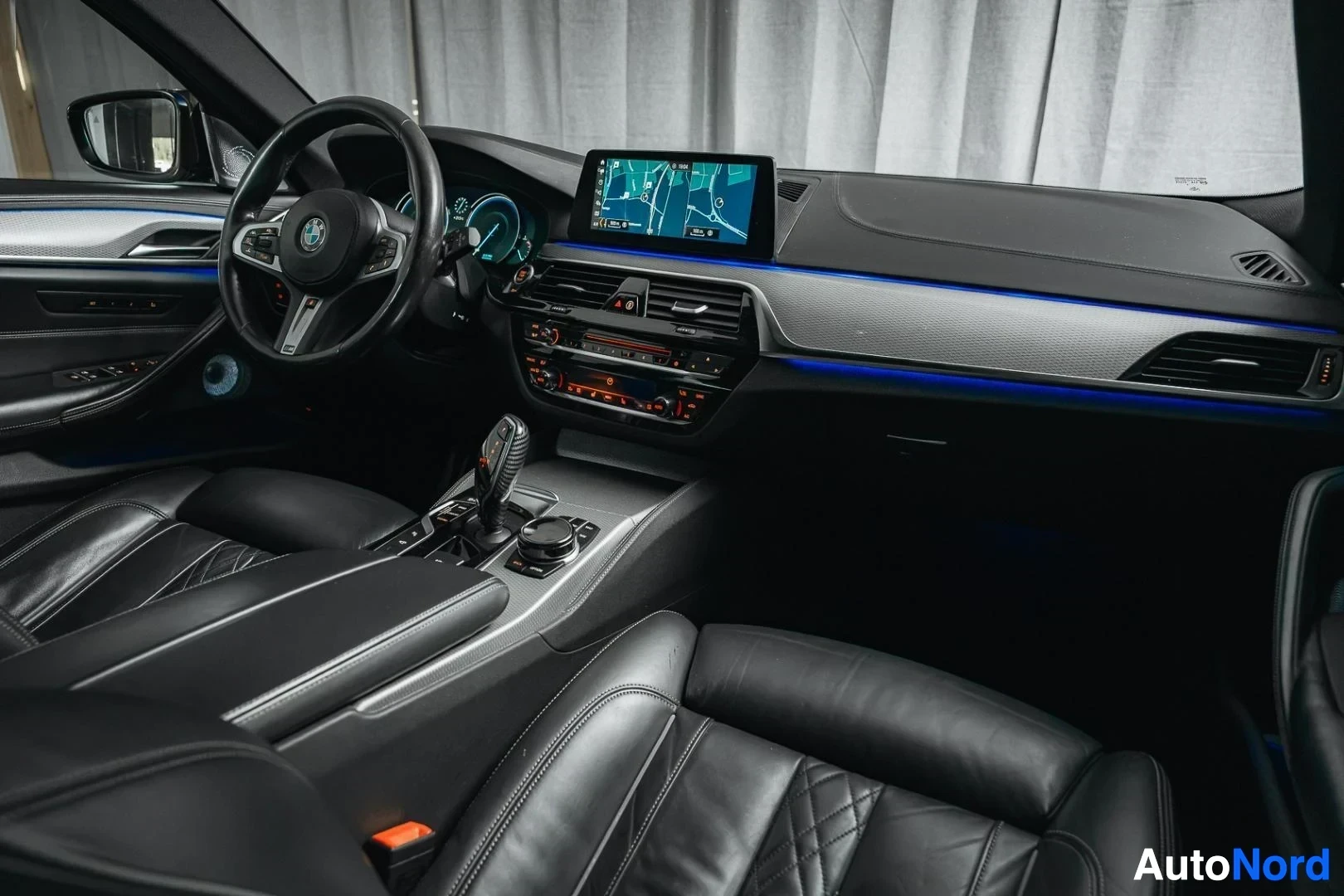 Ohjaamo: Hopeanharmaa BMW 540i G31 xDrive Touring, kojelauta ja etuistuimet matkustajan puolelta kuvattuna