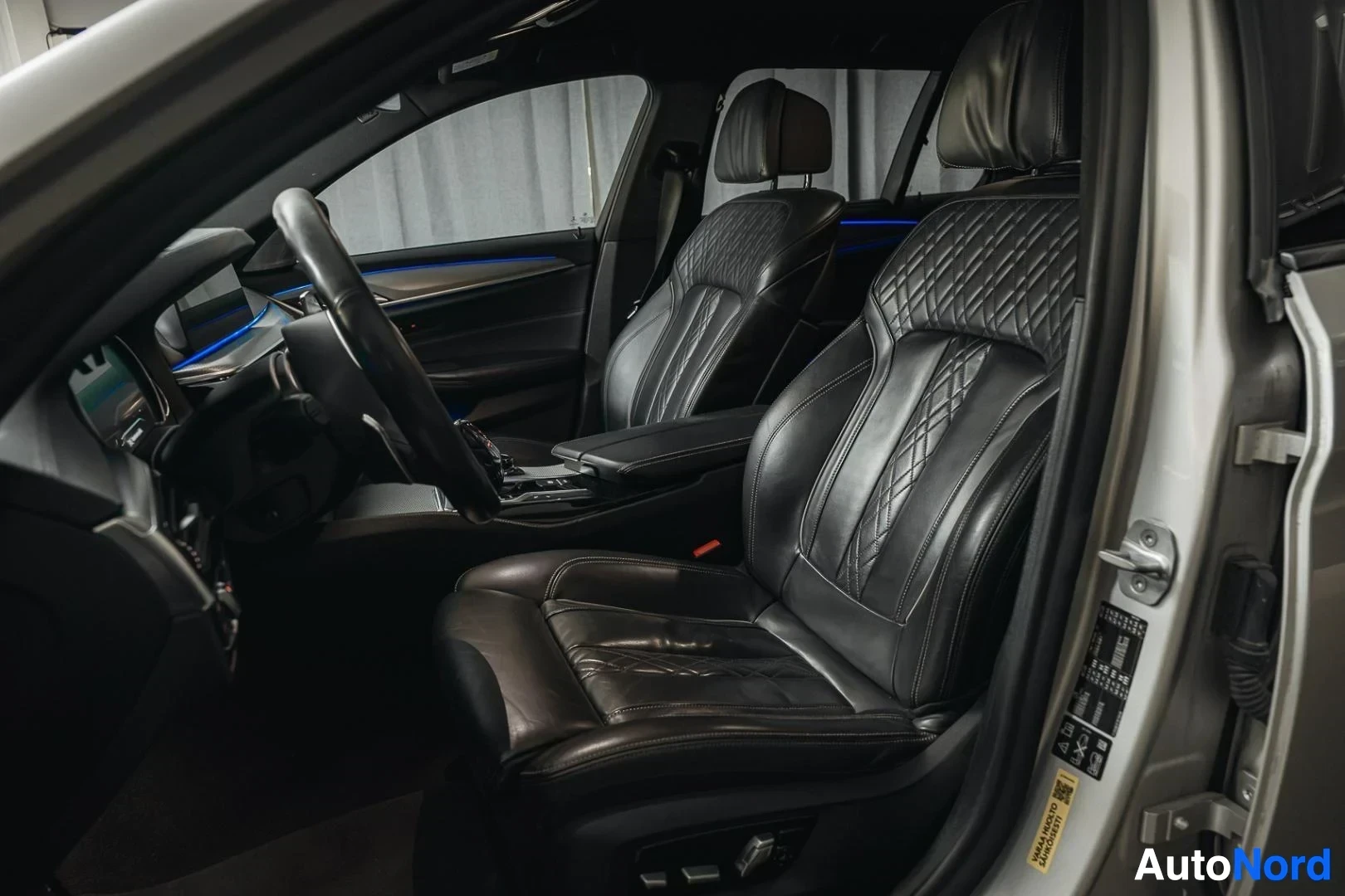 Etuistuimet: Hopeanharmaa BMW 540i G31 xDrive Touring, mustat nahkaverhoillut etuistuimet avoimesta ovesta
