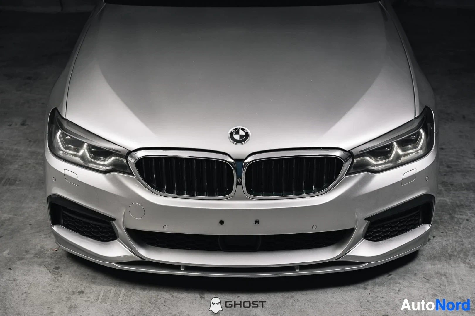 Edestä: Hopeanharmaa BMW 540i G31 xDrive Touring, lähikuva keulasta, munuaissäleikkö ja LED-ajovalot