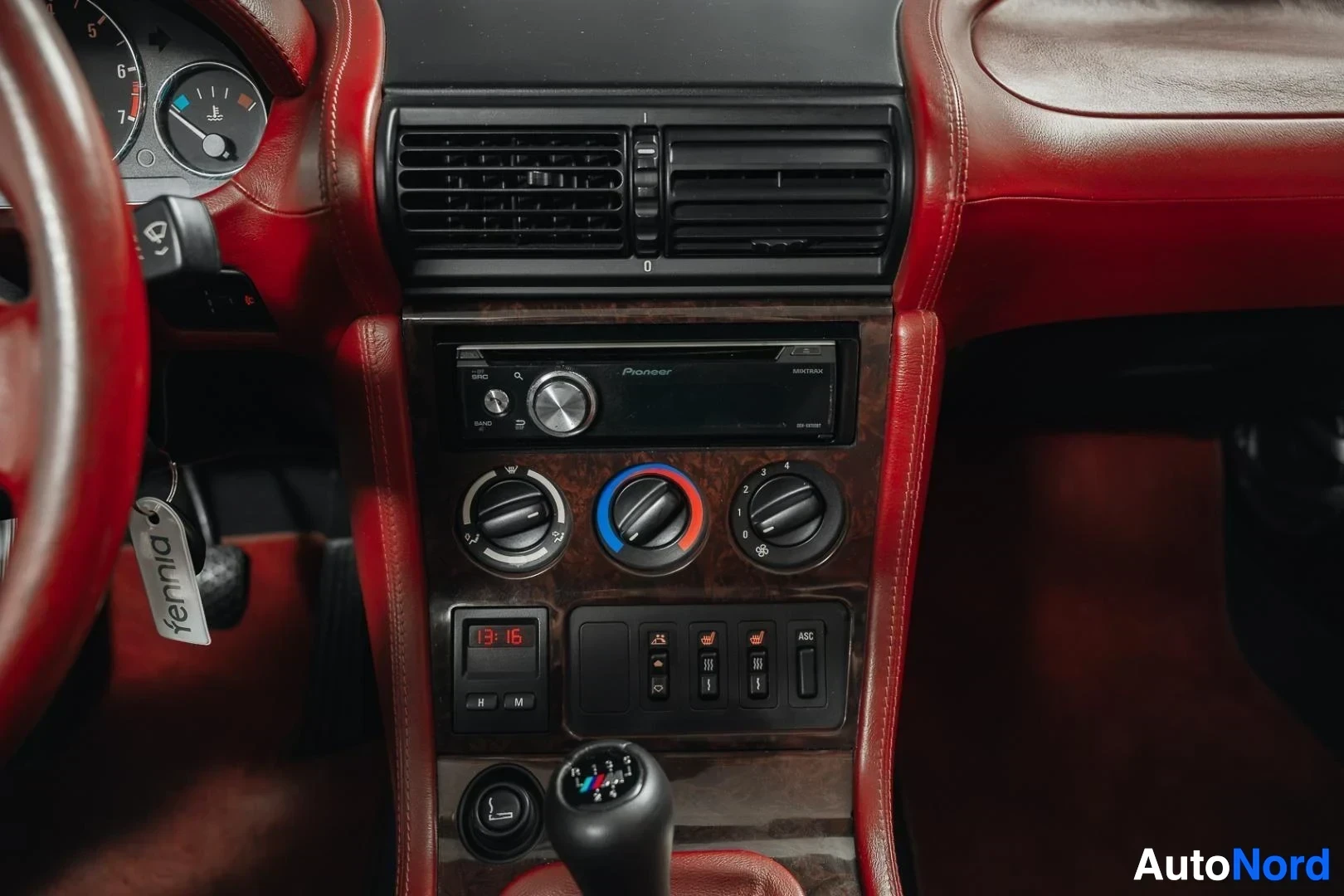 Yksityiskohta: Musta BMW Z3 Roadster, radio ja ilmastoinnin säätimet keskikonsolissa, vaihdekeppi