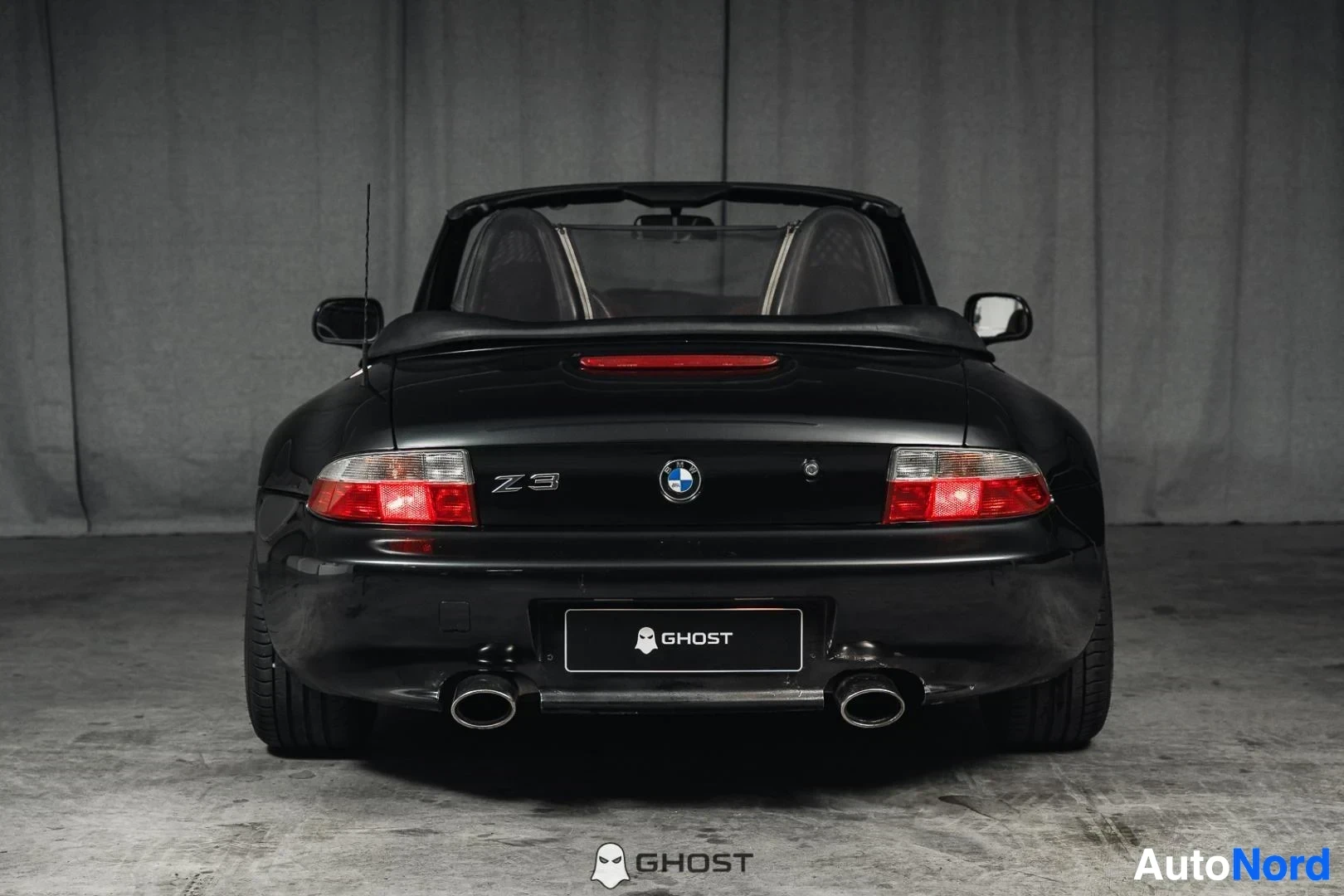 Takaa: Musta BMW Z3 Roadster, koko ajoneuvo näkyvissä, takaluukku, takavalot ja kaksoispakoputket