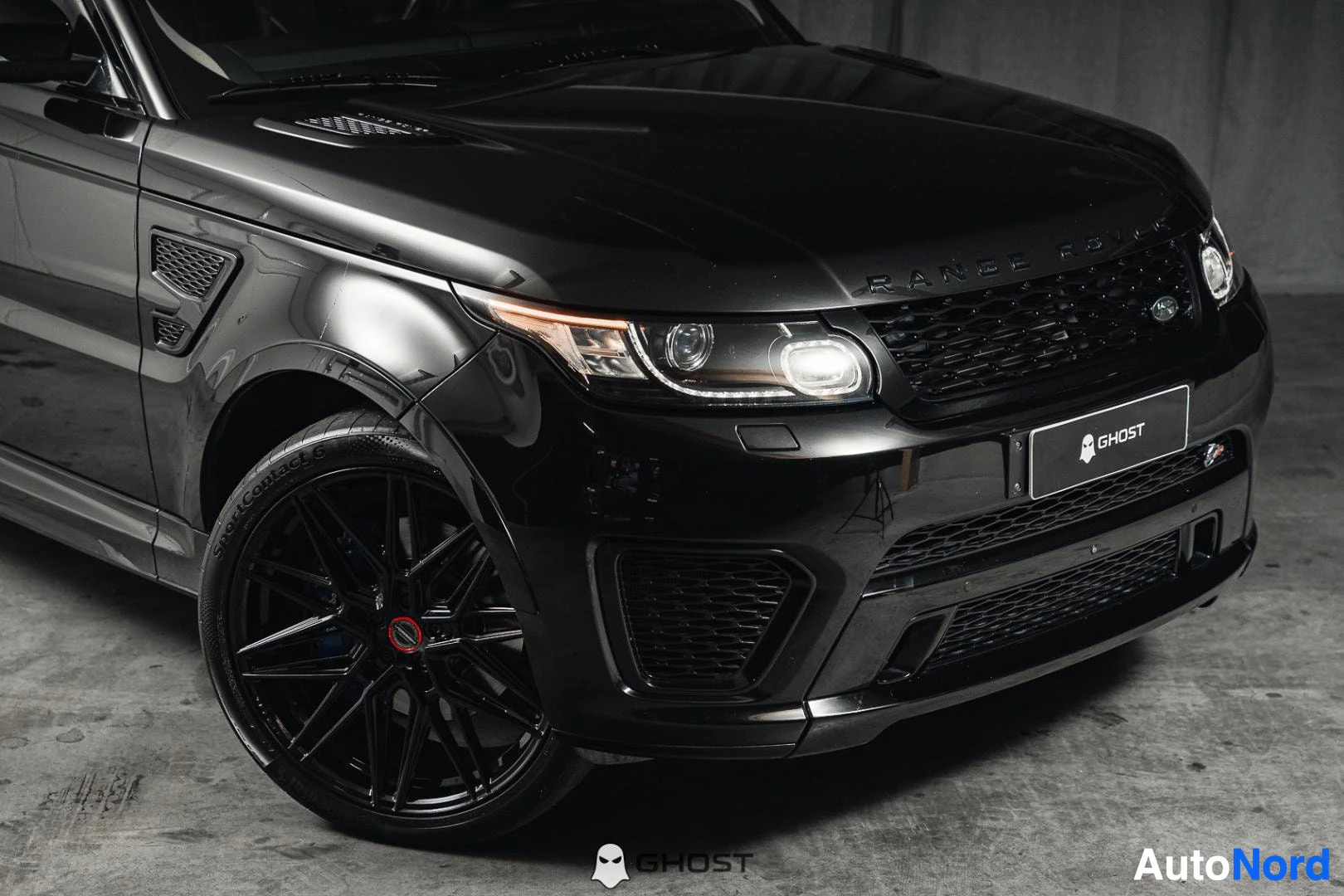 Etuviisto, nokka oikealle: Musta Land Rover Range Rover Sport, lähikuva keulasta ja mustasta etuvanteesta