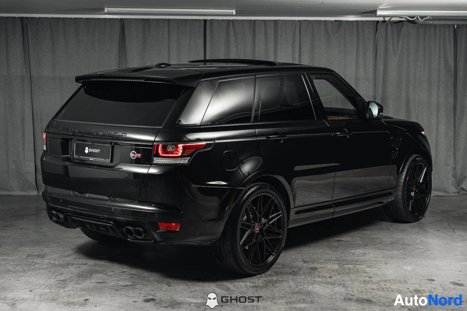 Takaviisto: Musta Land Rover Range Rover Sport, koko ajoneuvo näkyvissä, mustat vanteet, studiotausta