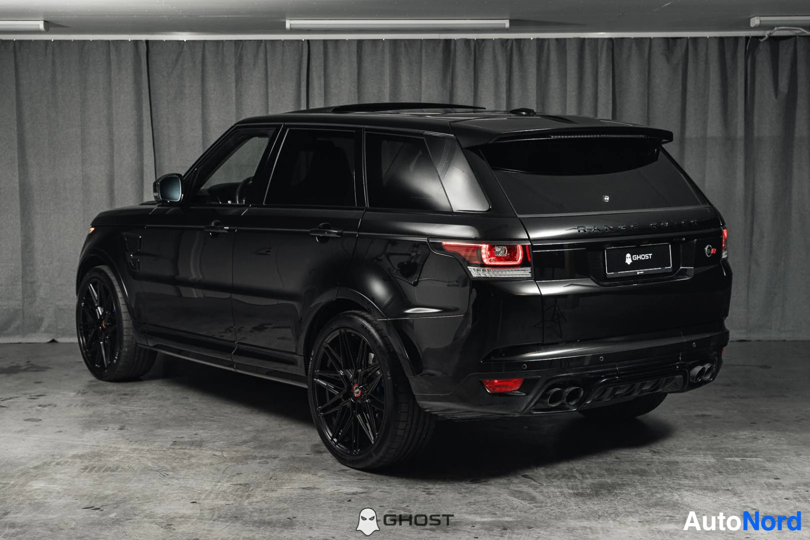 Takaviisto: Musta Land Rover Range Rover Sport, koko ajoneuvo näkyvissä sivusta ja takaa, studiotausta