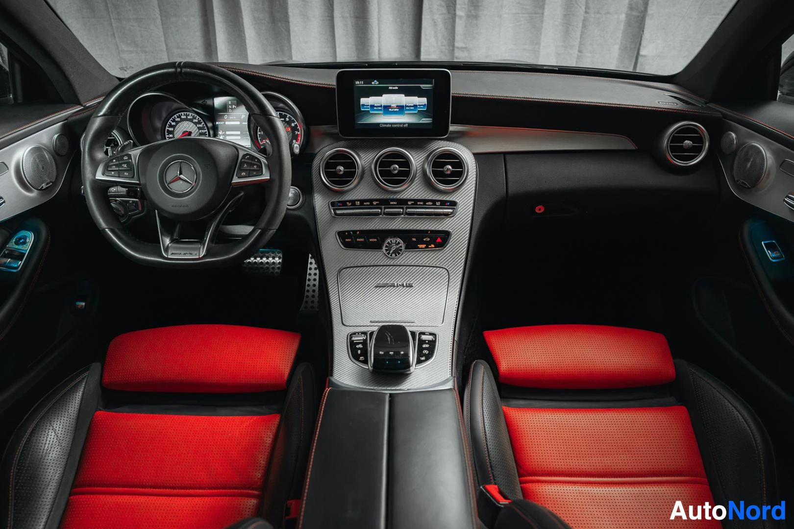 Ohjaamo: Mattamusta Mercedes-Benz C 63 AMG coupé, kojelauta, ohjauspyörä, keskinäyttö ja puna-mustat nahkaistuimet