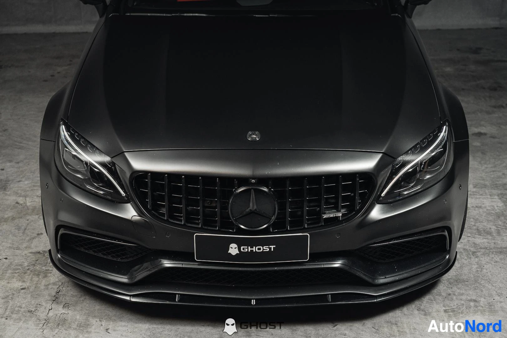 Edestä: Mattamusta Mercedes-Benz C 63 AMG coupé, lähikuva keulasta, ajovalot ja Panamericana-säleikkö