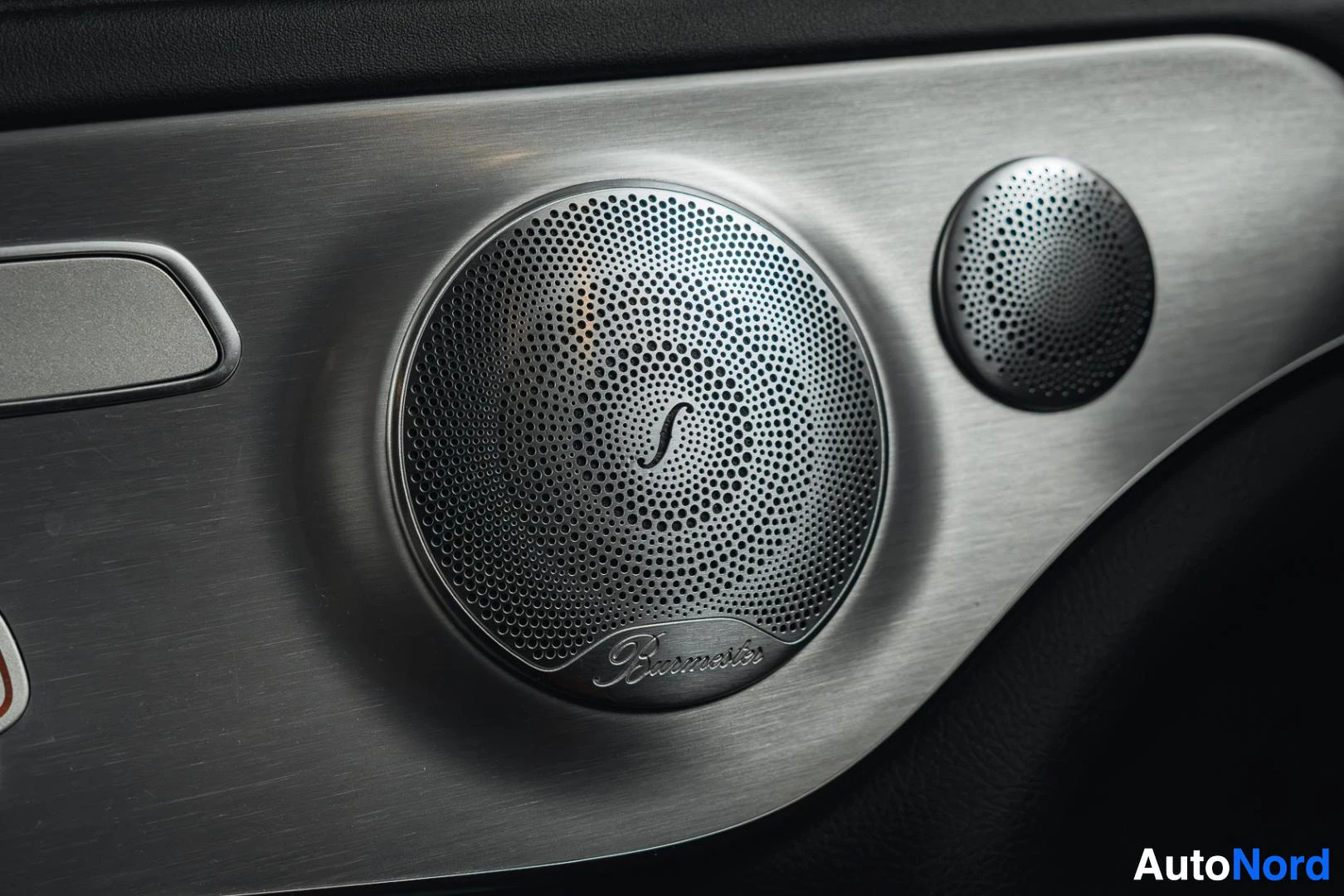 Yksityiskohta: Mattamusta Mercedes-Benz C 63 AMG coupé, Burmester-kaiutin ovessa