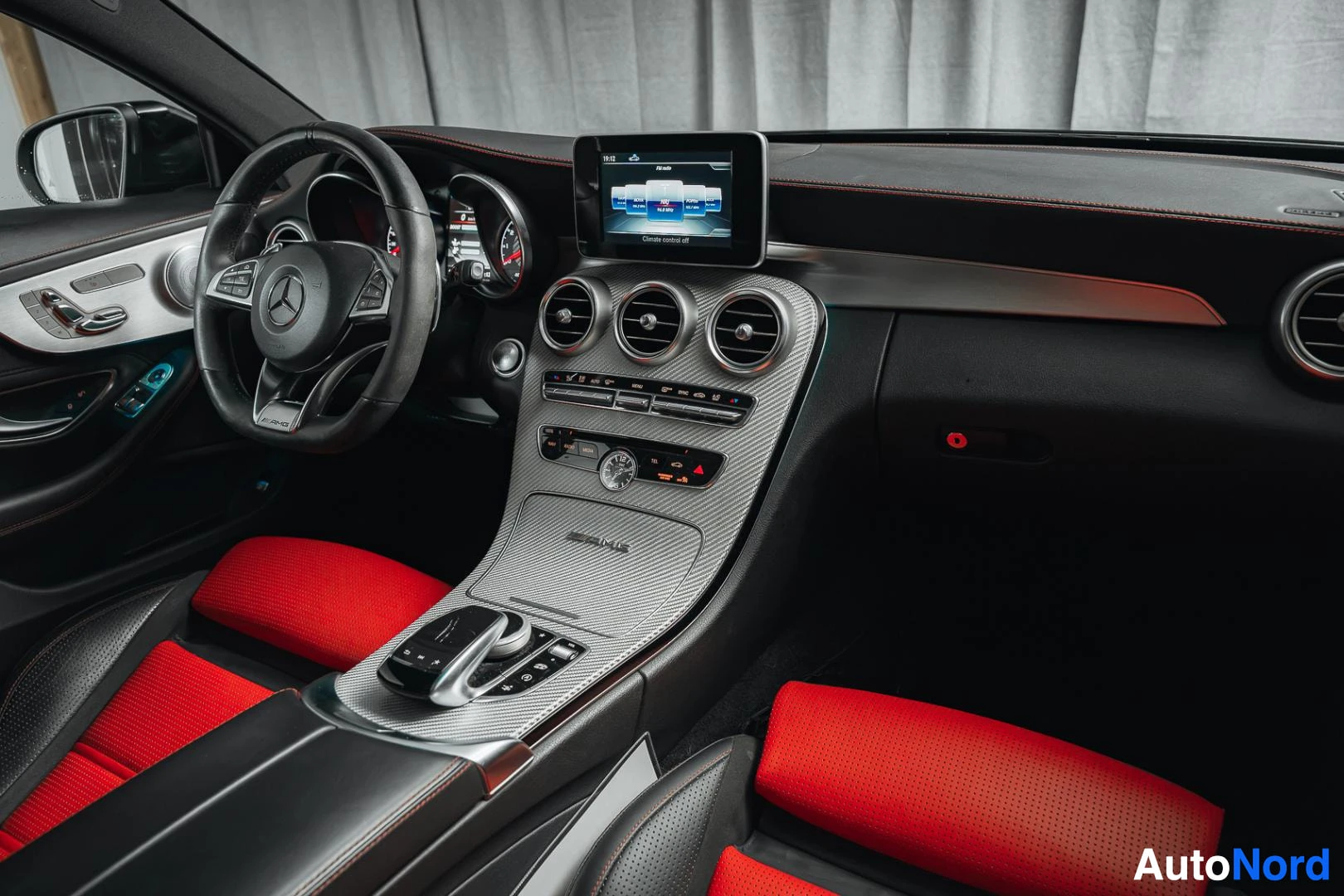 Ohjaamo: Mattamusta Mercedes-Benz C 63 AMG coupé, kojelauta matkustajan puolelta, keskinäyttö ja puna-mustat istuimet