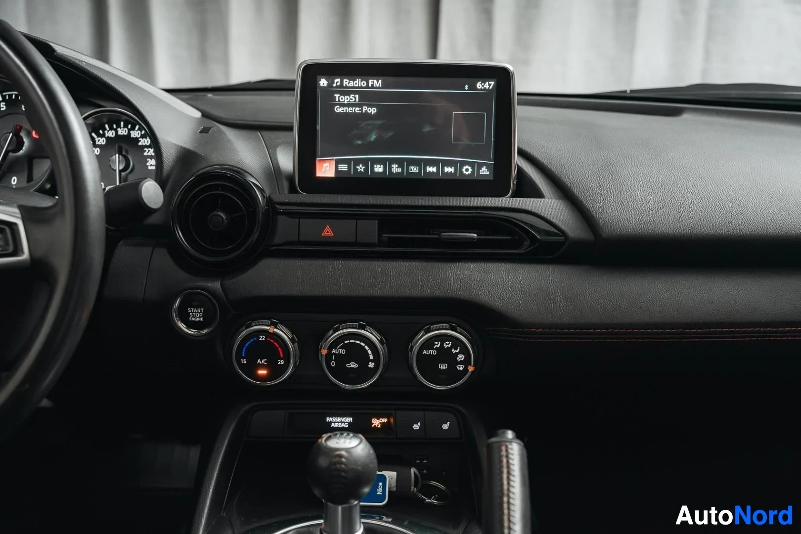 Yksityiskohta: Punainen Mazda MX-5, keskinäyttö ja ilmastoinnin säätimet