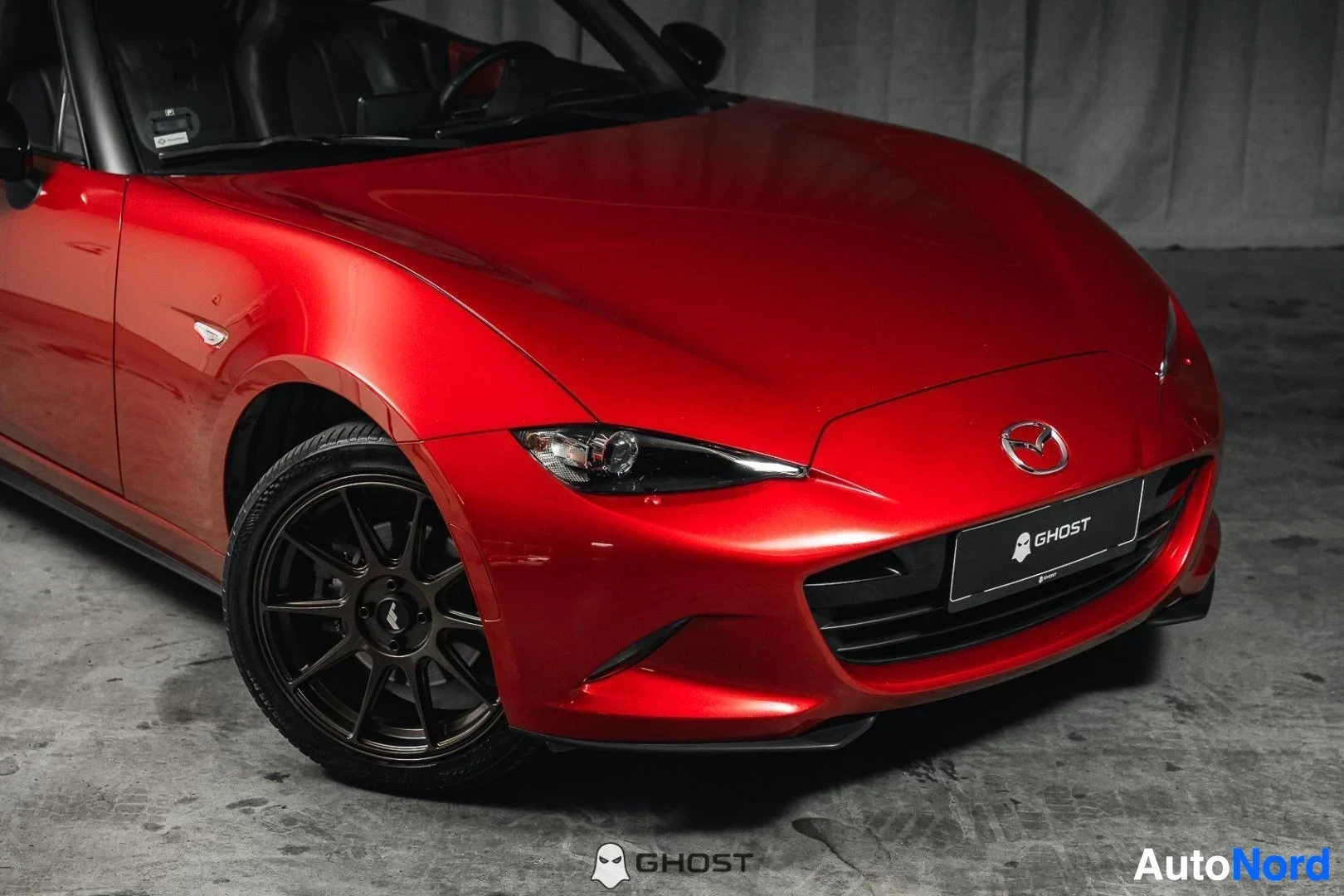 Etuviisto, nokka oikealle: Punainen Mazda MX-5, lähikuva keulasta ja tummasta etuvanteesta