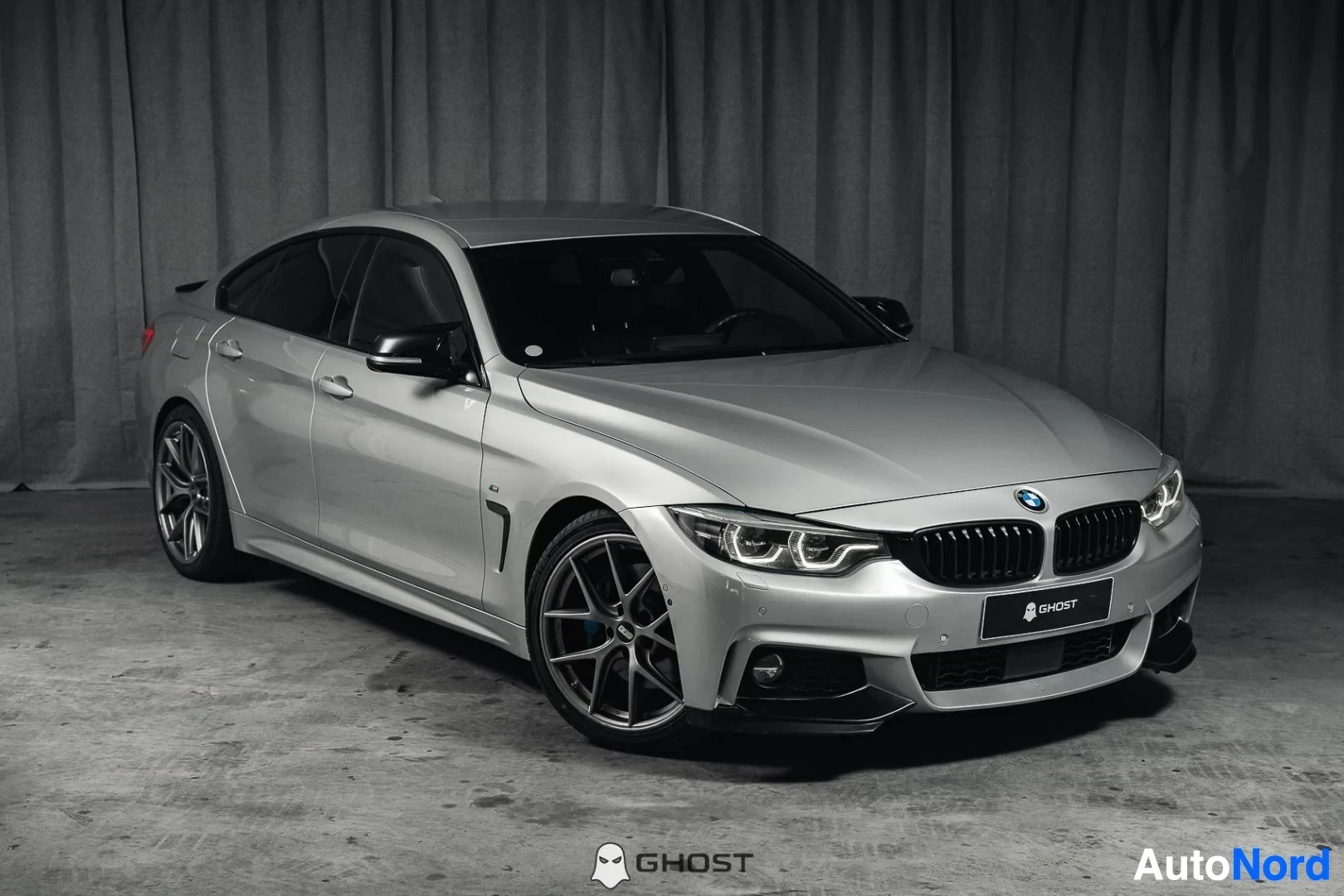 Etuviisto, nokka oikealle: Hopeanharmaa BMW 440i F36 Gran Coupé, koko ajoneuvo näkyvissä, M-Sport-paketti, mustat vanteet, studiotausta