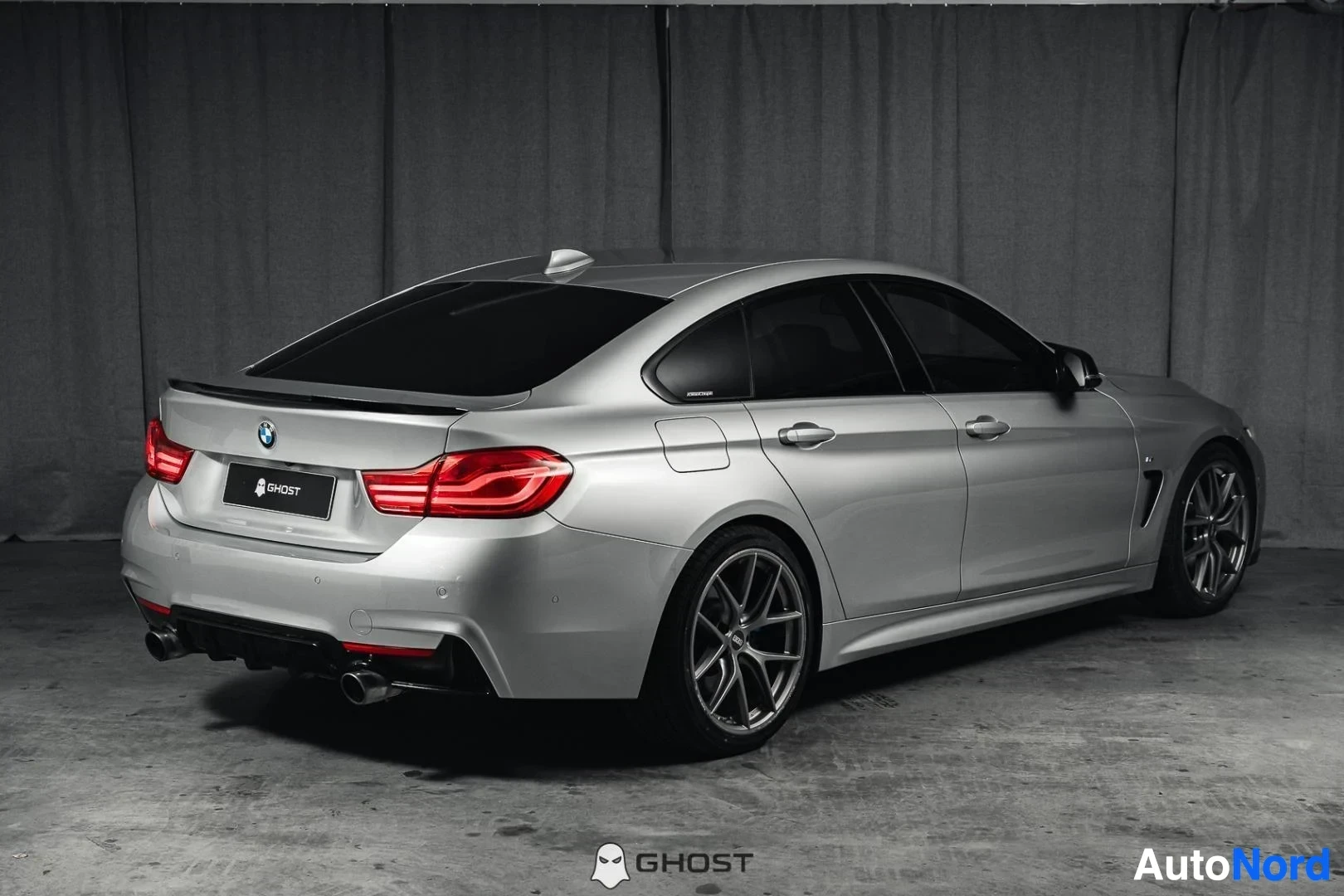 Takaviisto: Hopeanharmaa BMW 440i F36 Gran Coupé, koko ajoneuvo näkyvissä, takaosa ja kylki, LED-takavalot, studiotausta