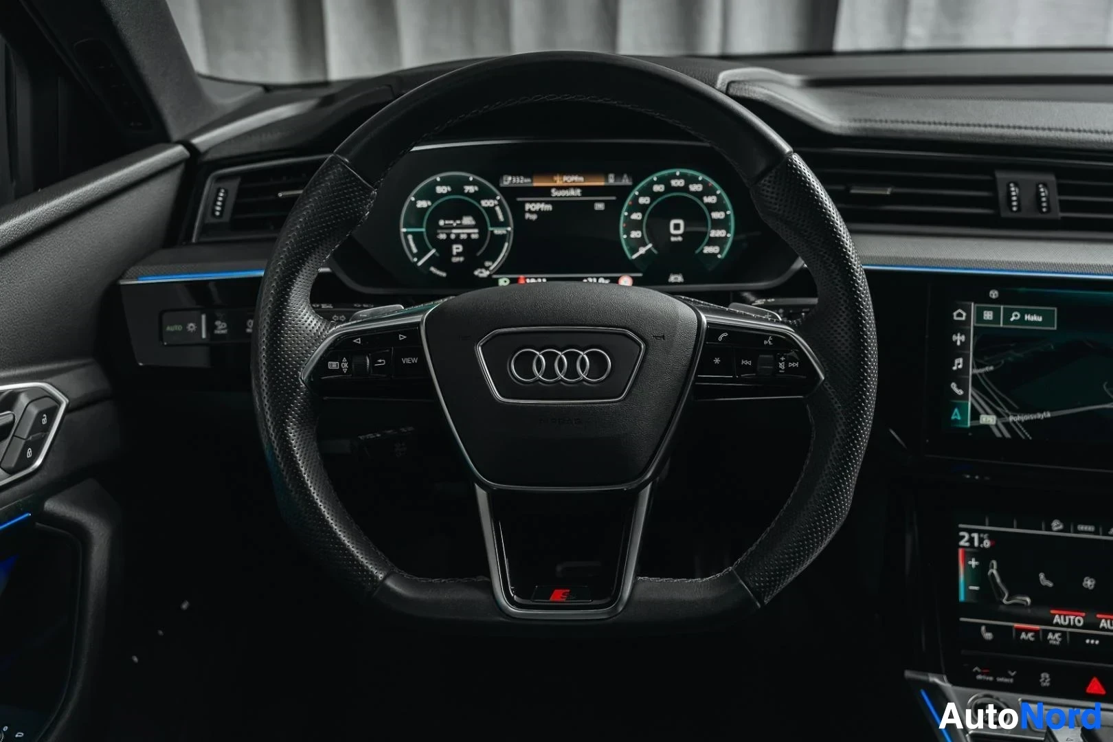 Ohjaamo: Tummanvihreä Audi Q8 e-tron, ohjauspyörä ja digitaalinen mittaristo kuljettajan puolelta