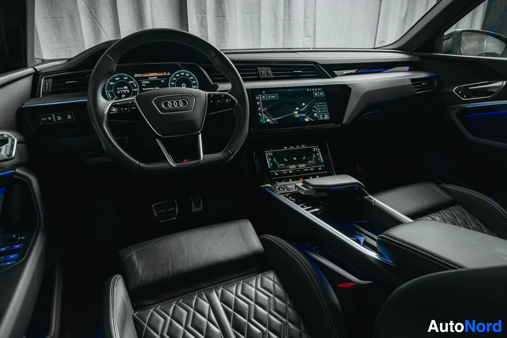 Ohjaamo: Tummanvihreä Audi Q8 e-tron, kojelauta ja ohjauspyörä matkustajan puolelta, tunnelmavalaistus