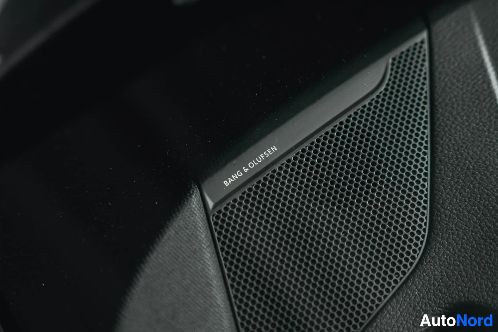 Yksityiskohta: Tummanvihreä Audi Q8 e-tron, Bang & Olufsen -kaiuttimen ritilä ovessa