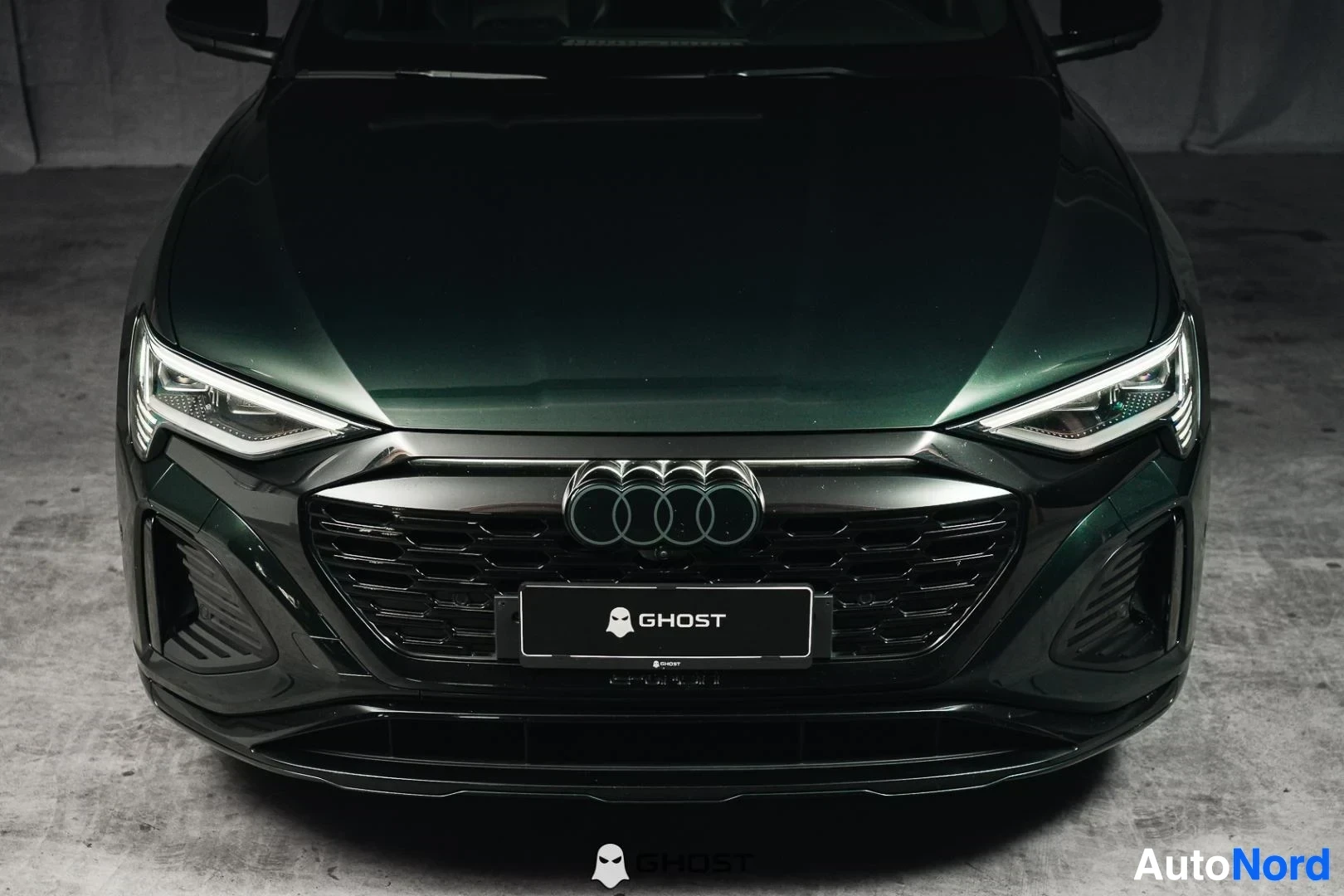 Edestä: Tummanvihreä Audi Q8 e-tron Sportback, lähikuva keulasta, säleikkö ja LED-ajovalot