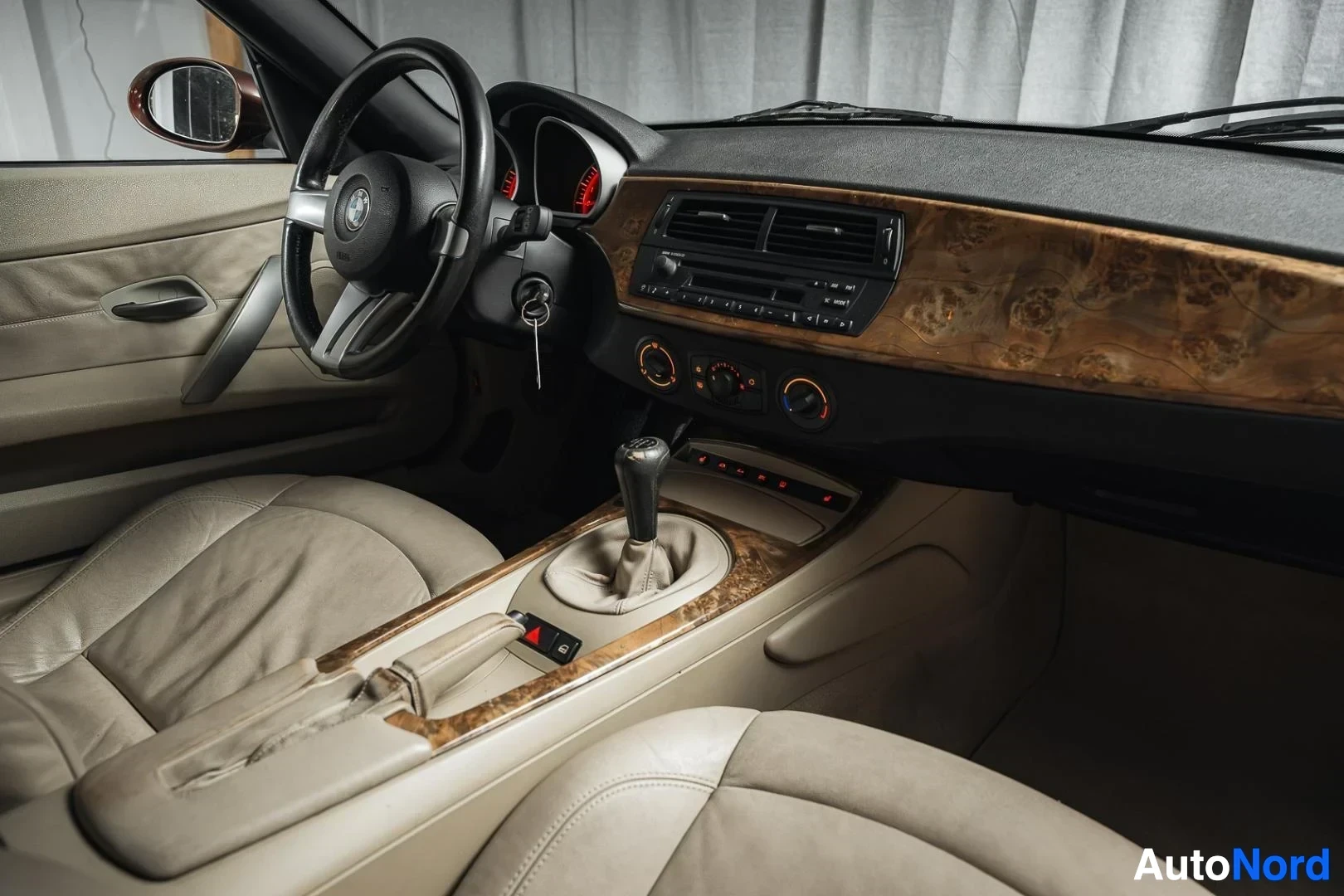 Ohjaamo: Tummanpunainen BMW Z4 E85 Roadster, kojelauta ja etuistuimet matkustajan puolelta kuvattuna, beige nahkaverhoilu