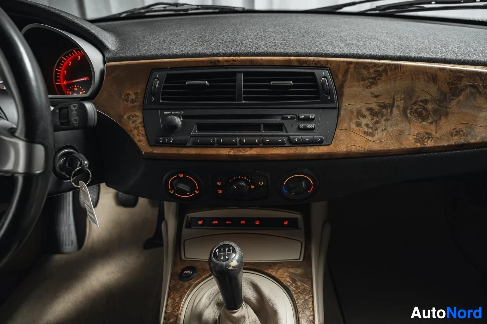 Yksityiskohta: Tummanpunainen BMW Z4 E85 Roadster, keskikonsoli, radio ja ilmastoinnin säätimet, puukoristelu