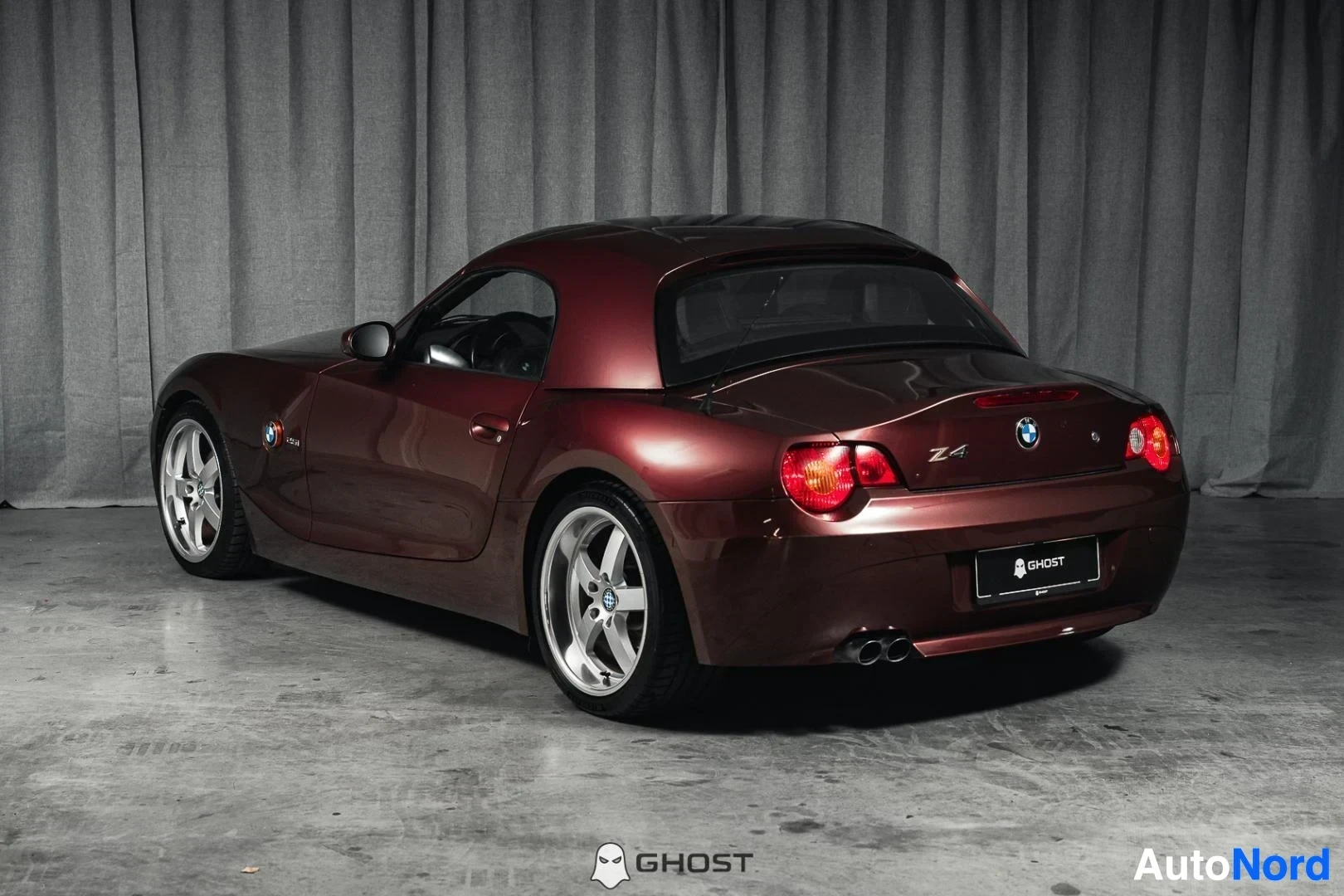 Takaviisto: Tummanpunainen BMW Z4 E85 Roadster, koko ajoneuvo näkyvissä, takavalot ja kylki, studiotausta