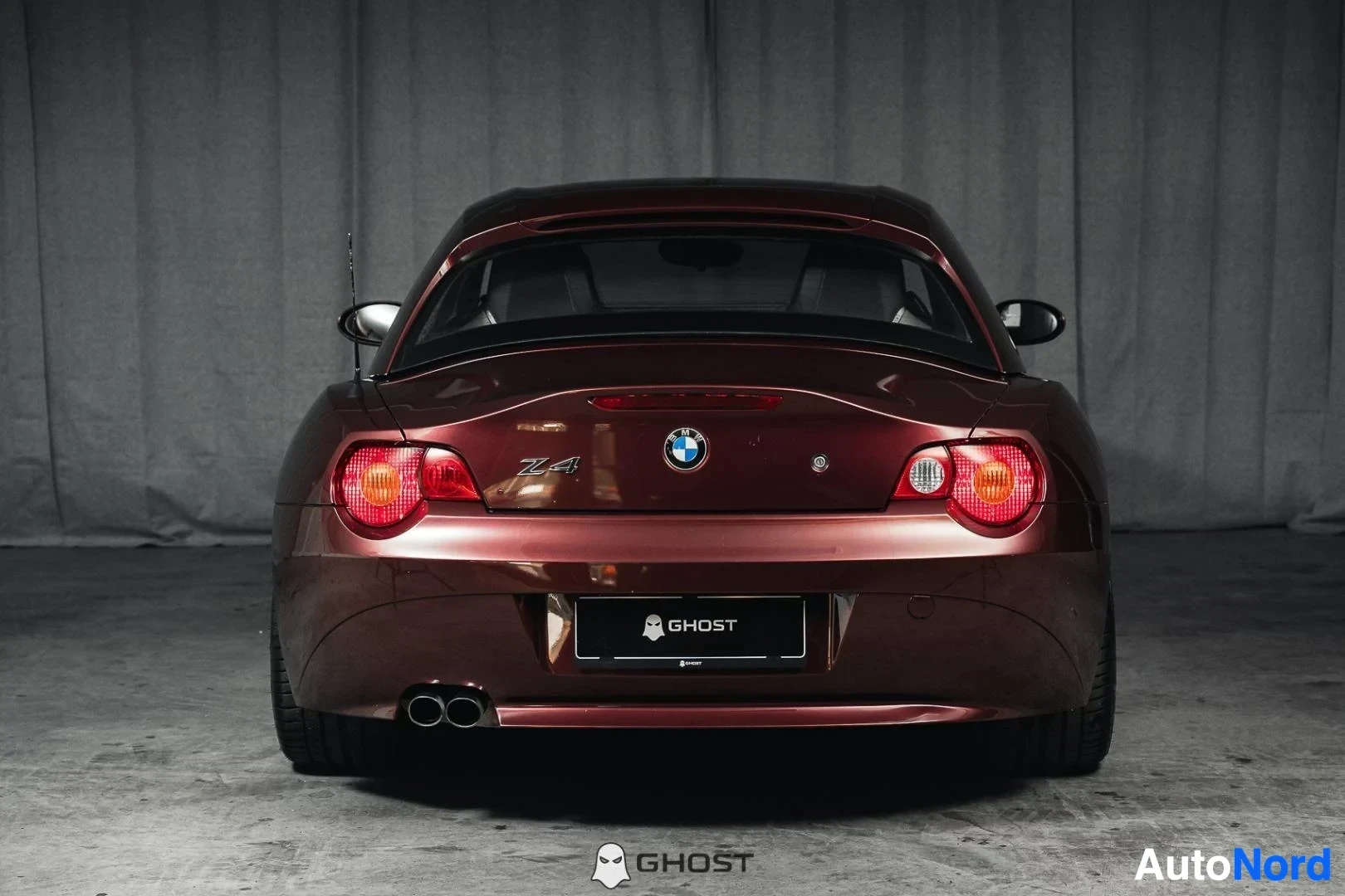 Takaa: Tummanpunainen BMW Z4 E85 Roadster, koko ajoneuvo näkyvissä, takaluukku, takavalot ja kaksoispakoputket