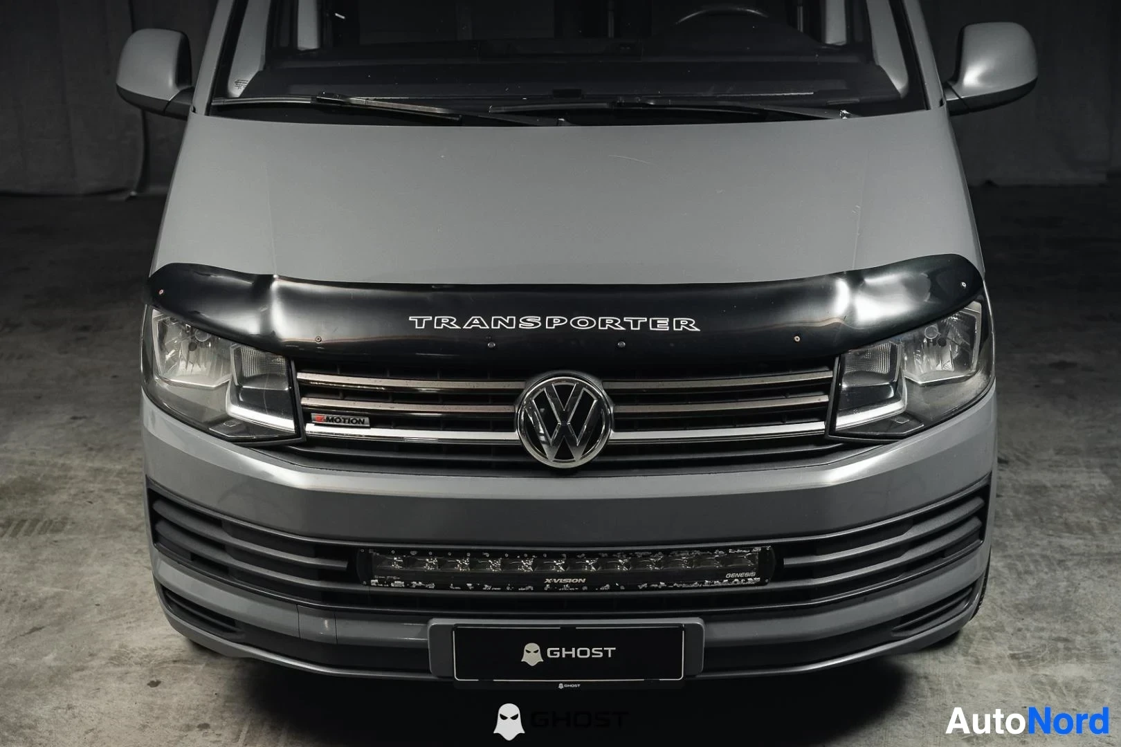 Edestä: Harmaa Volkswagen Transporter, lähikuva keulasta, säleikkö ja konepellin suoja