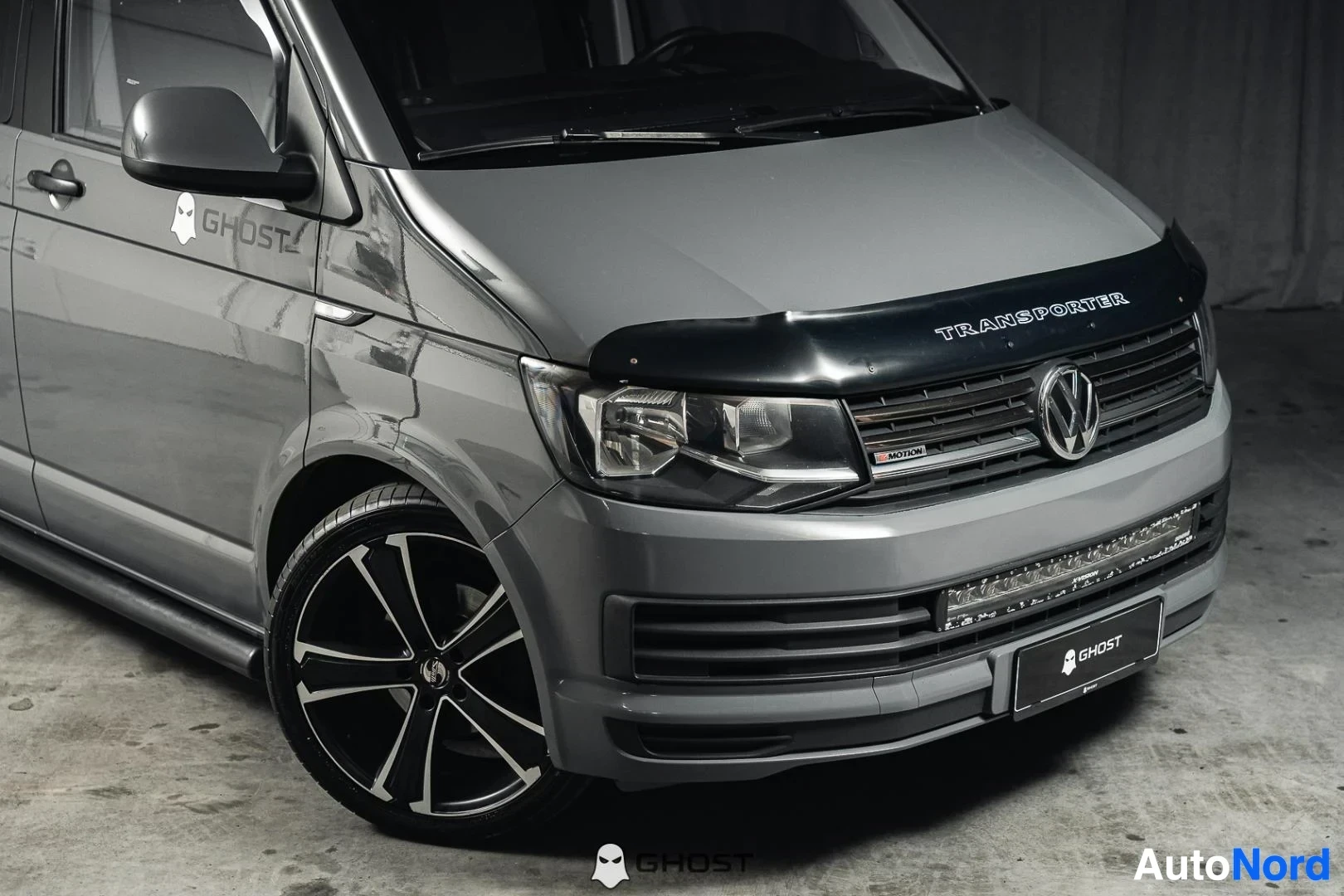 Etuviisto, nokka oikealle: Harmaa Volkswagen Transporter, lähikuva keulasta ja etuvanteesta