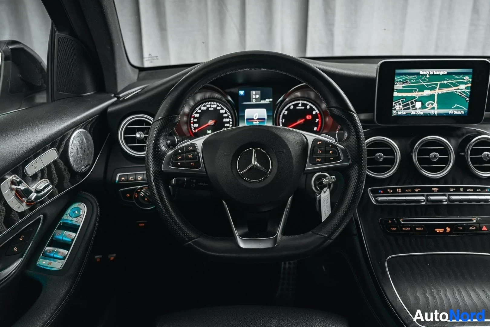 Ohjaamo: Valkoinen Mercedes-Benz GLC 350e coupé, ohjauspyörä, mittaristo ja keskinäyttö