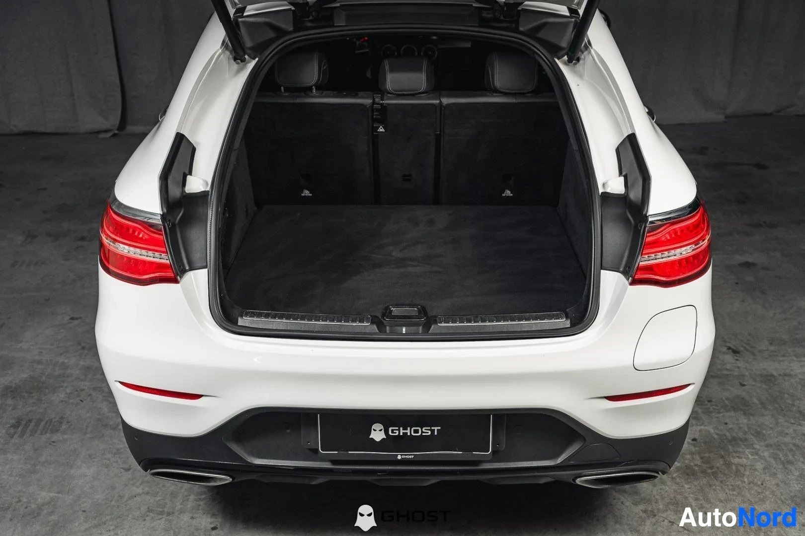 Tavaratila: Valkoinen Mercedes-Benz GLC 350e coupé, avattu takaluukku ja tavaratila