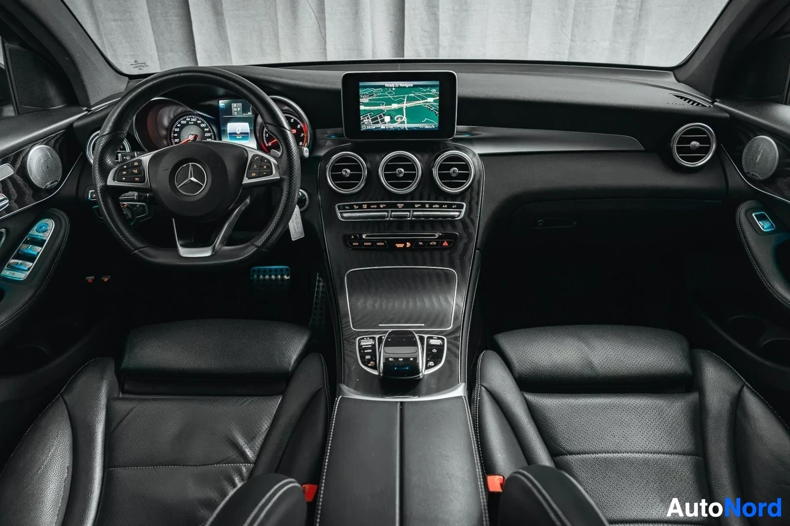 Ohjaamo: Valkoinen Mercedes-Benz GLC 350e coupé, kojelauta, ohjauspyörä, keskinäyttö ja mustat nahkaistuimet