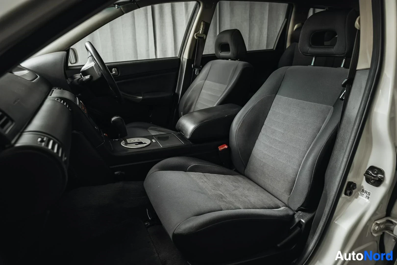 Etuistuimet: Valkoinen Nissan Stagea, tummat etuistuimet kuljettajan ovelta