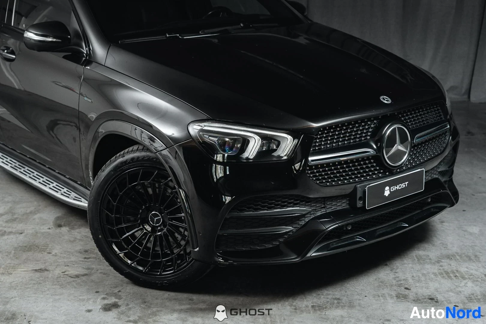 Etuviisto, nokka oikealle: Musta Mercedes-Benz GLE, lähikuva keulasta ja etuvanteesta, mustat vanteet