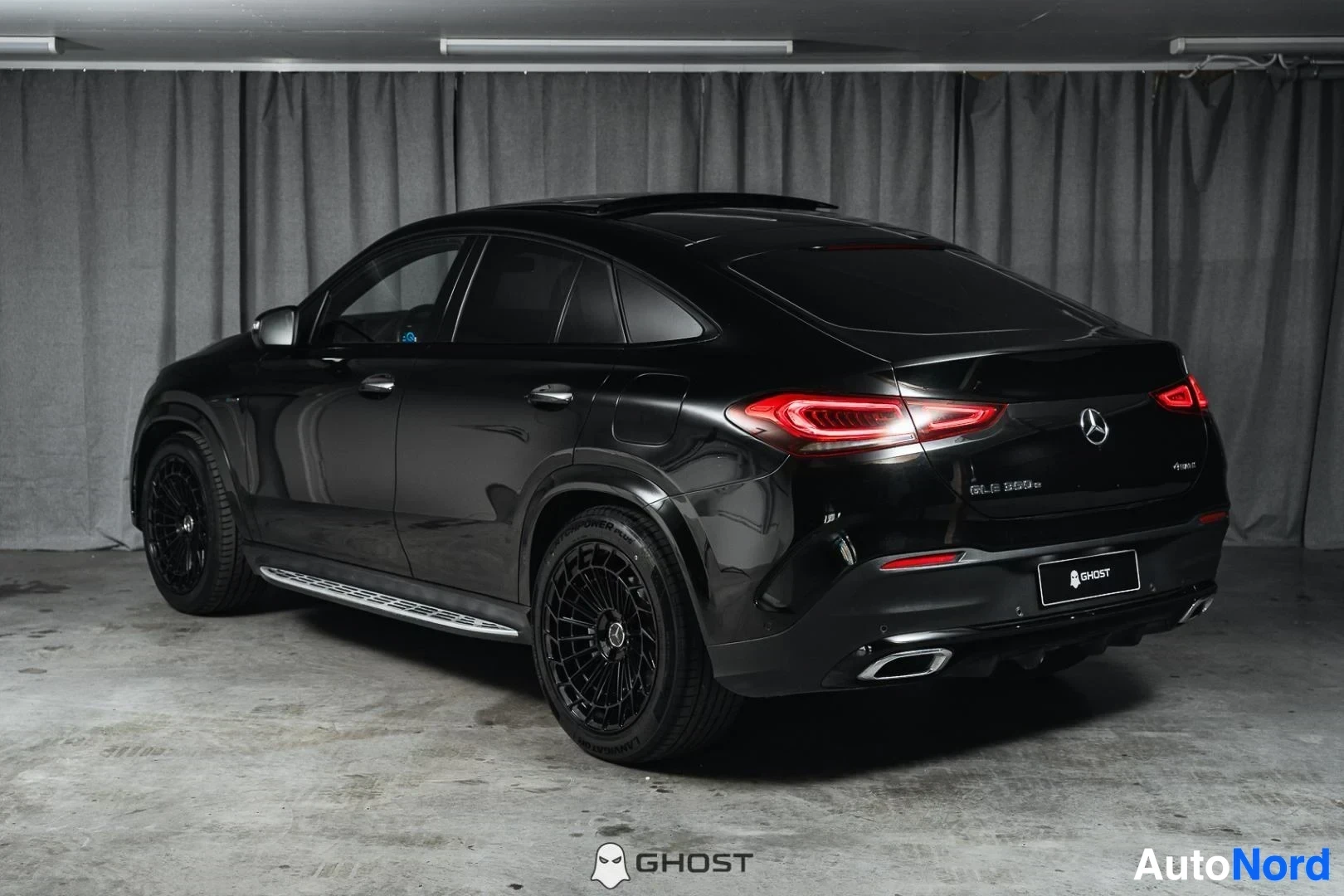 Takaviisto: Musta Mercedes-Benz GLE Coupé, koko ajoneuvo näkyvissä, mustat vanteet, studiotausta