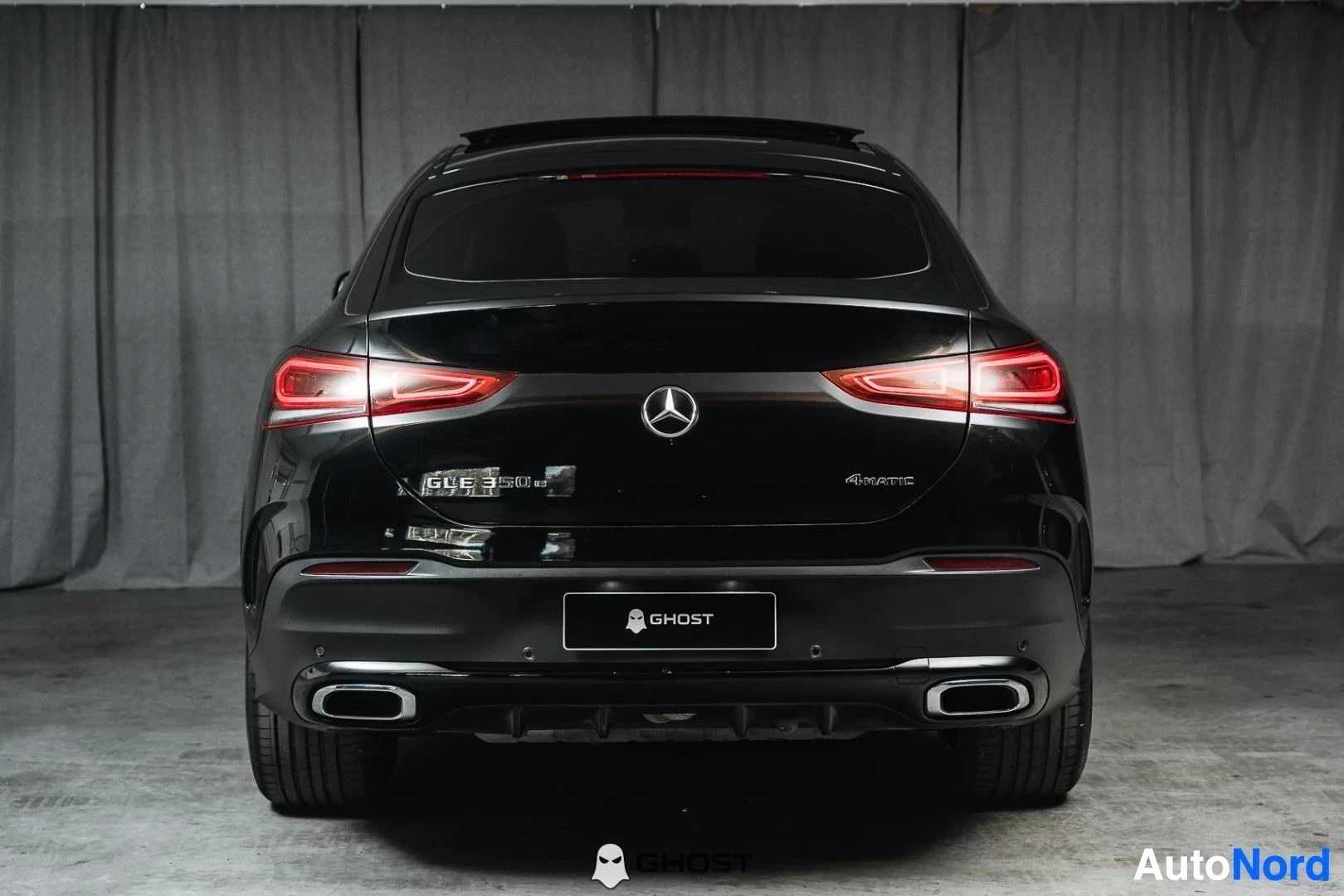Takaa: Musta Mercedes-Benz GLE, koko ajoneuvo näkyvissä, LED-takavalot ja kaksoispakoputket, studiotausta