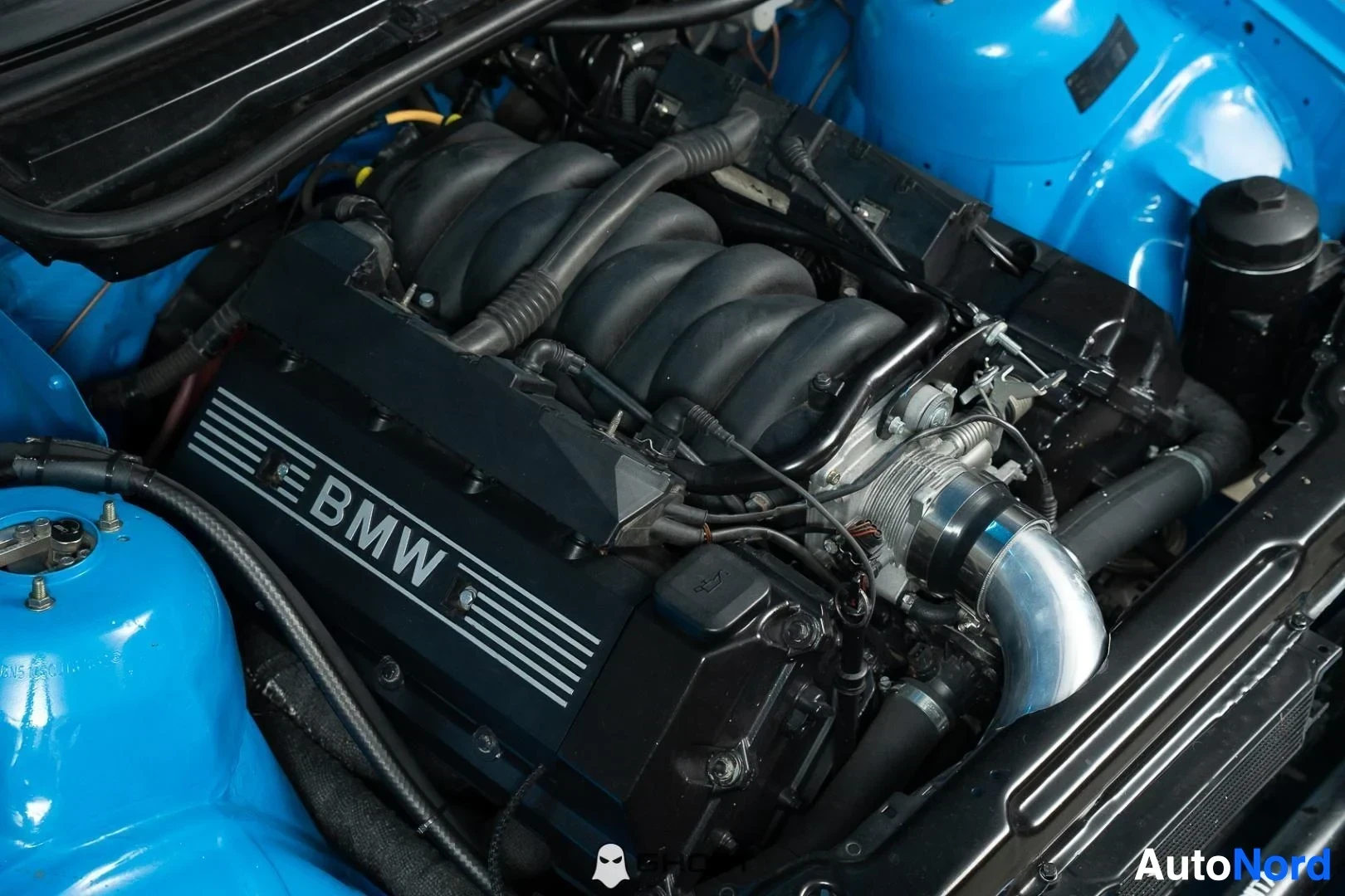Moottoritila: Sininen BMW 330 kilpa-auto, lähikuva V8-moottorista ja imusarjasta