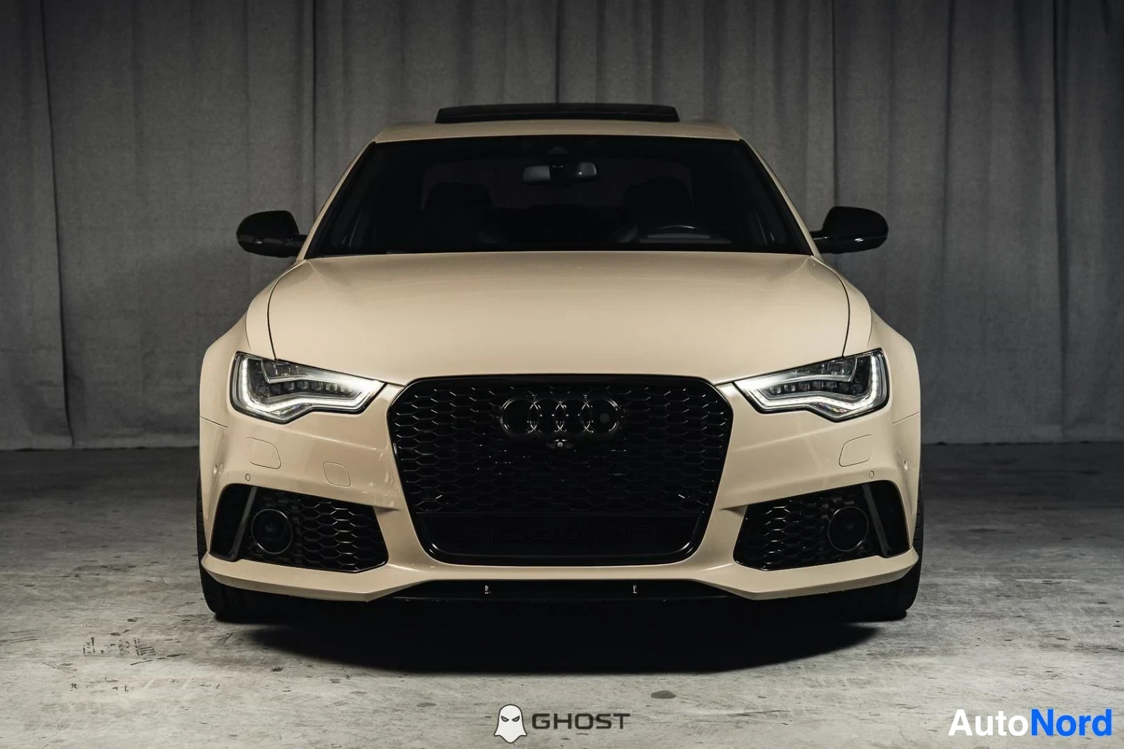 Edestä: Beige Audi S6, koko ajoneuvo näkyvissä, musta hunajakennosäleikkö ja LED-ajovalot