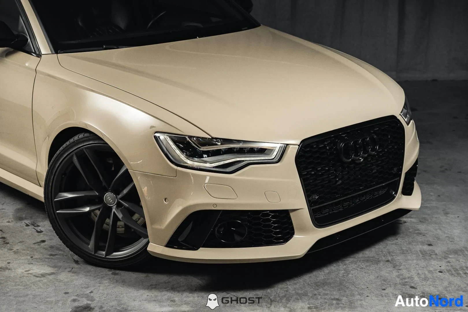 Etuviisto, nokka oikealle: Beige Audi S6, lähikuva keulasta ja etupyörästä, mustat vanteet