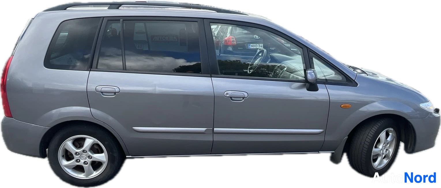 Sivulta: Harmaa farmariauto, jossa on kattokaiteet ja alumiinivanteet, kuvattuna oikealta sivulta mustalla taustalla.