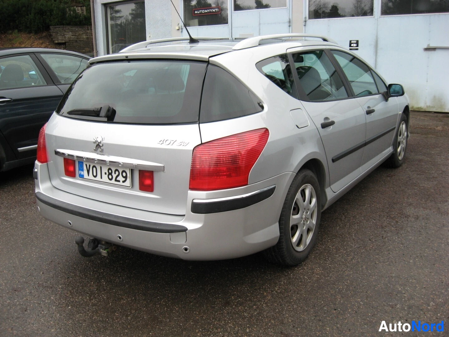 Takaviisto: Valkoinen Peugeot 407 farmari takaa, rekisterinumero VO1-829, punainen takavalo näkyvissä
