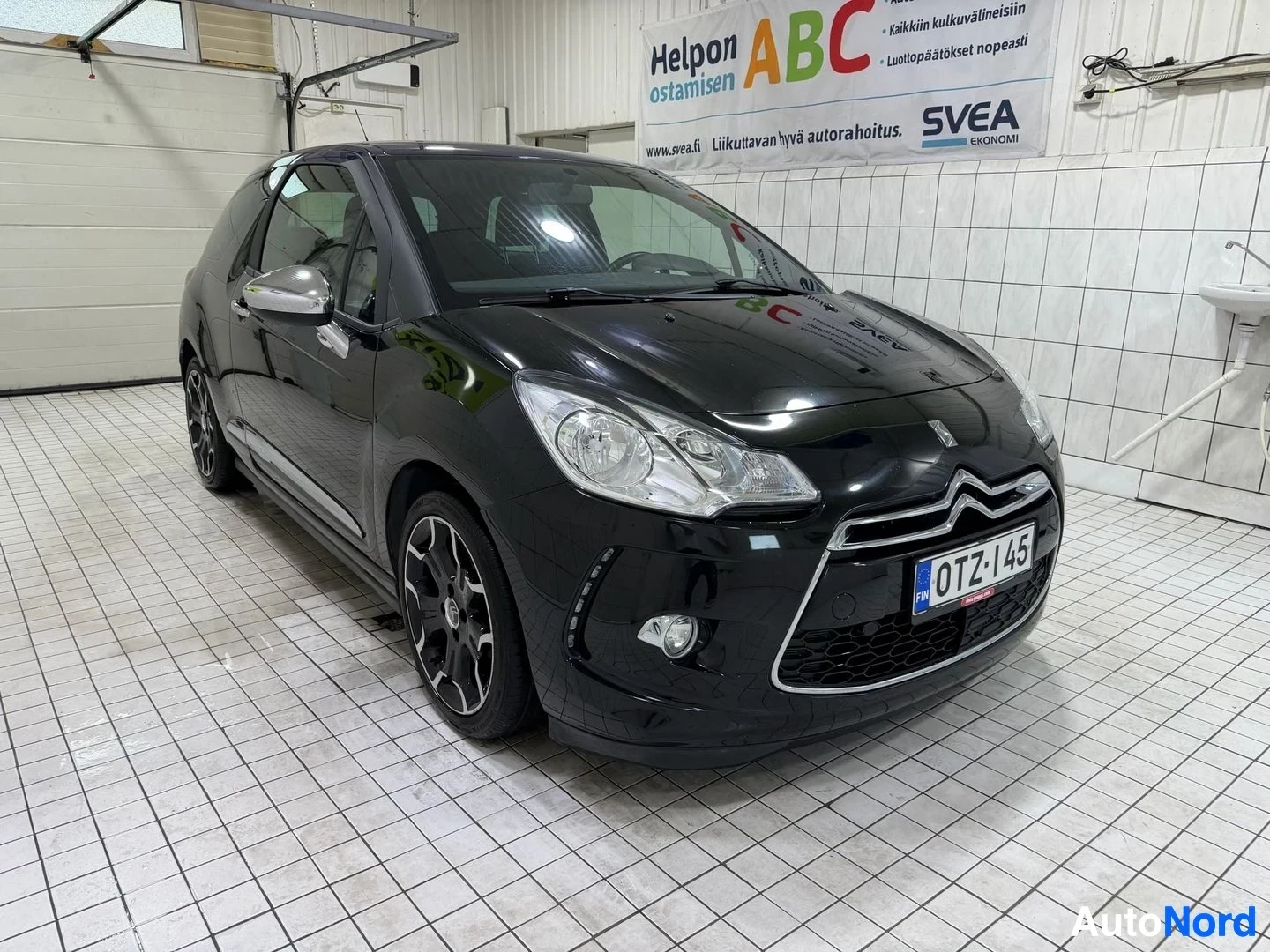 Etuviisto, nokka vasemmalle: Musta Citroën DS3 kolmen neljäsosan näkymästä vasemmalta puolelta, etupää osoittaa kohti kameraa vasemmalle, rekisterikyltti näkyy selvästi etu
