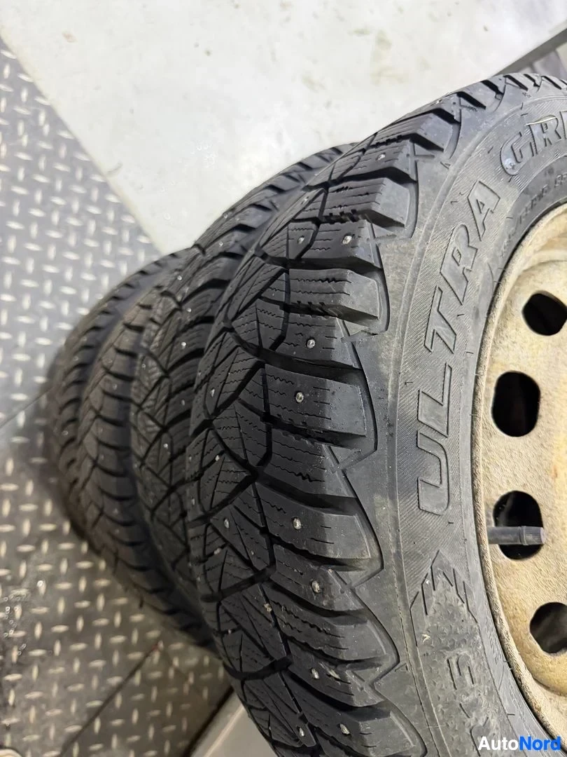 Yksityiskohta: Talvirengas lähikuva, teräsnavan vanteella, ULTRA GRIP -merkinnällä, piikkiulokkeilla