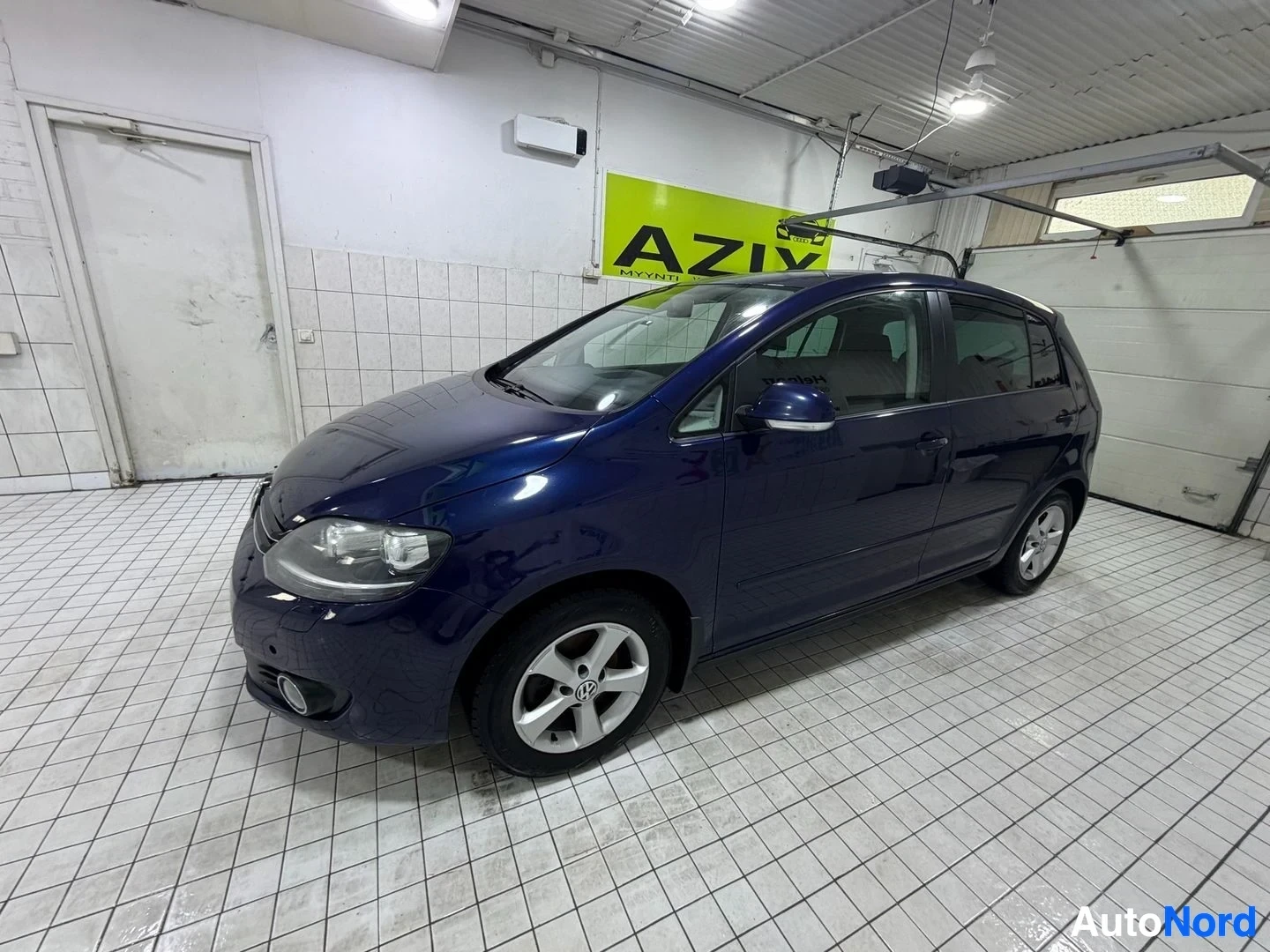 Etuviisto, nokka oikealle: Tummansininen Volkswagen Golf Plus etuviistosta oikealta puolelta kuvattuna. Autossa on viisipuolaiset alumiinivanteet. Ajoneuvo on pysäköity laatoitetus