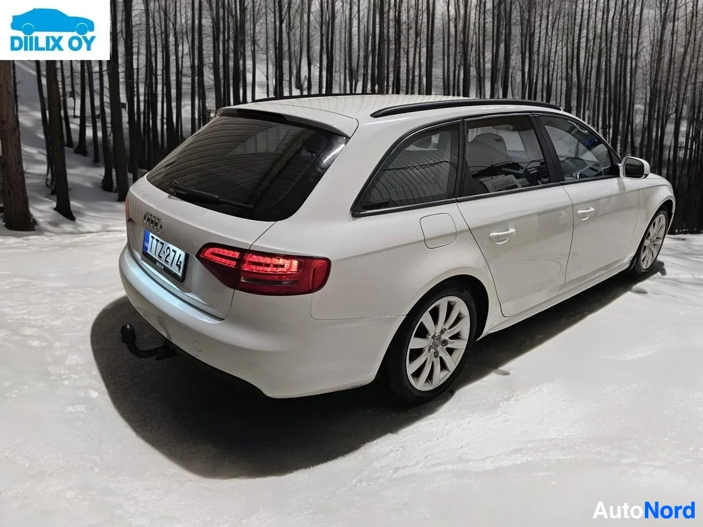 Takaviisto: Valkoinen Audi A4 Avant kuvattu takakolmelta sivulta, näkyvät takavalaisttimet, katto ja osa sivusta.