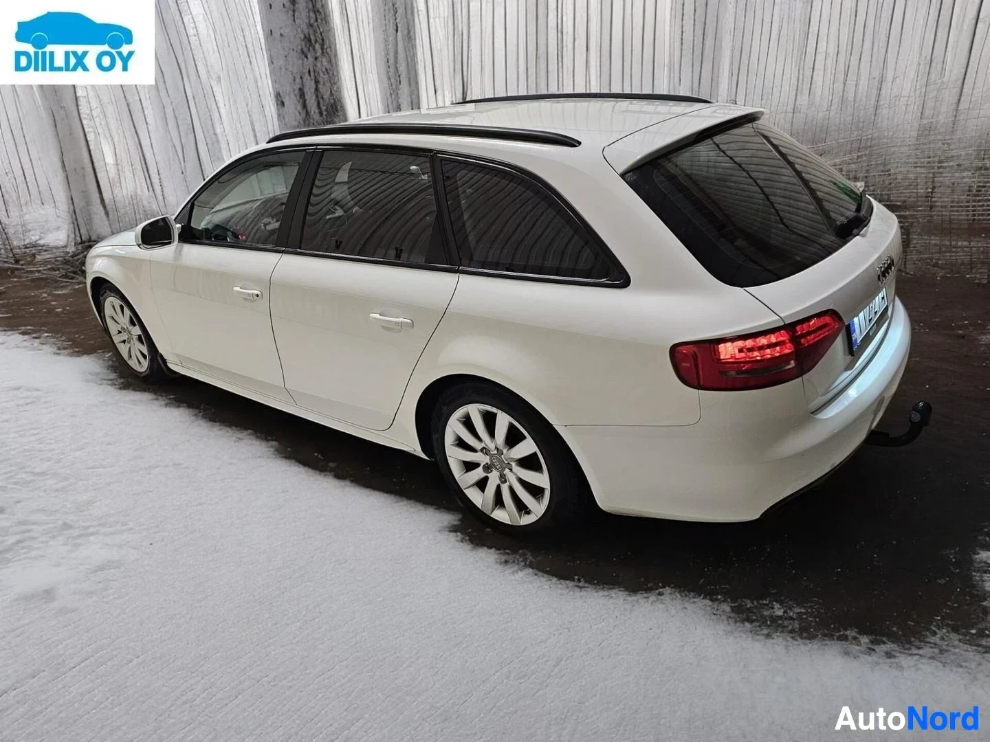 Takaviisto: Valkoinen Audi A4 Avant kuvattu takakolmelta sivulta, näkyvät takavalaisttimet, katto, ovi ja siipi.