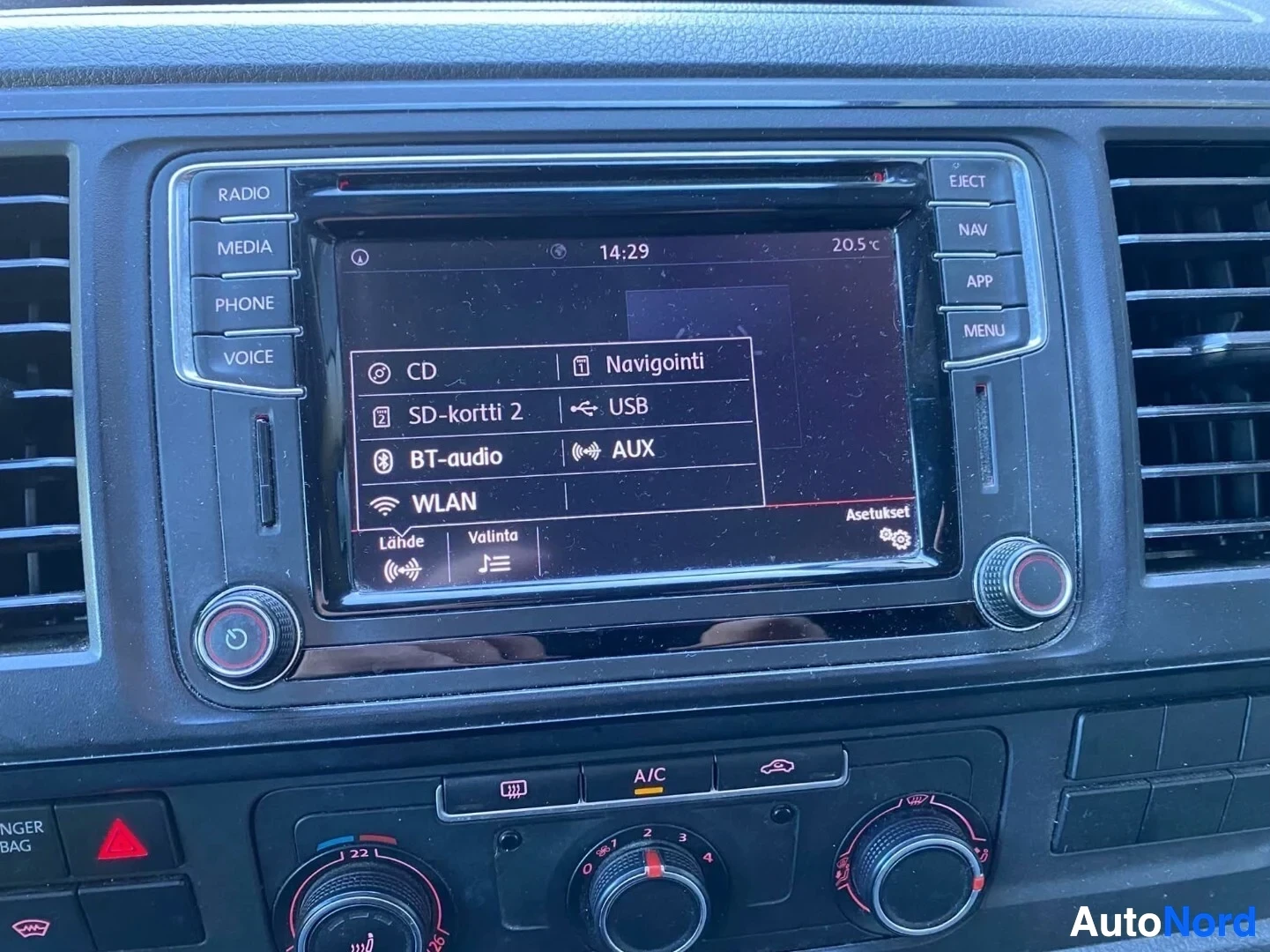 Ohjaamo: Kuva auton infotainment-järjestelmän näytöstä, jossa näkyy navigaation, Bluetooth-audion ja USB-liitännän valintavalikko. Ilmastoinnin säätimet ovat näkyvissä n