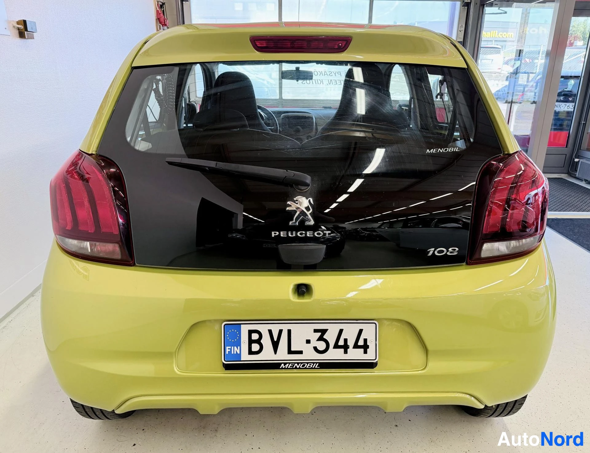 Takaa: Kuvassa vaaleanvihreä henkilöauto takaa päin. Takaluukussa on Peugeot-logo ja "108"-merkintä. Rekisterikilpi "" on näkyvissä