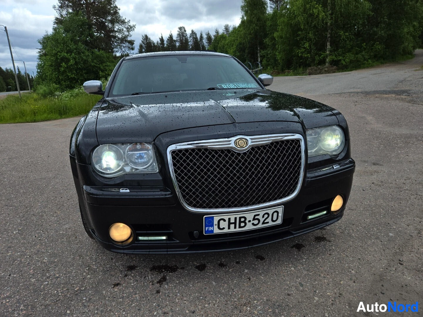 Edestä: Mustan Chrysler 300C farmarin etuosa kuvattuna edestä päin. Rekisterikilpi näkyy etupuskurissa
